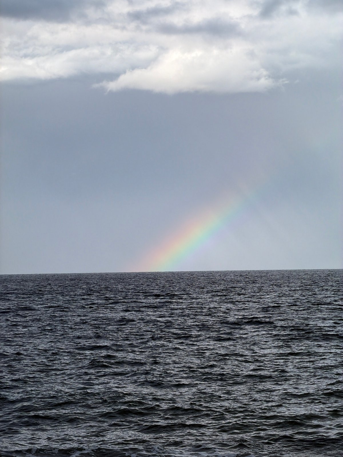 Coastal Spain witnesses document rainbow, clouds over beach scenes