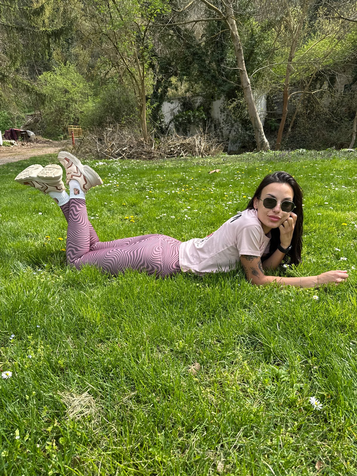 Woman relaxes in flower field, cat rests nearby in Pleven
