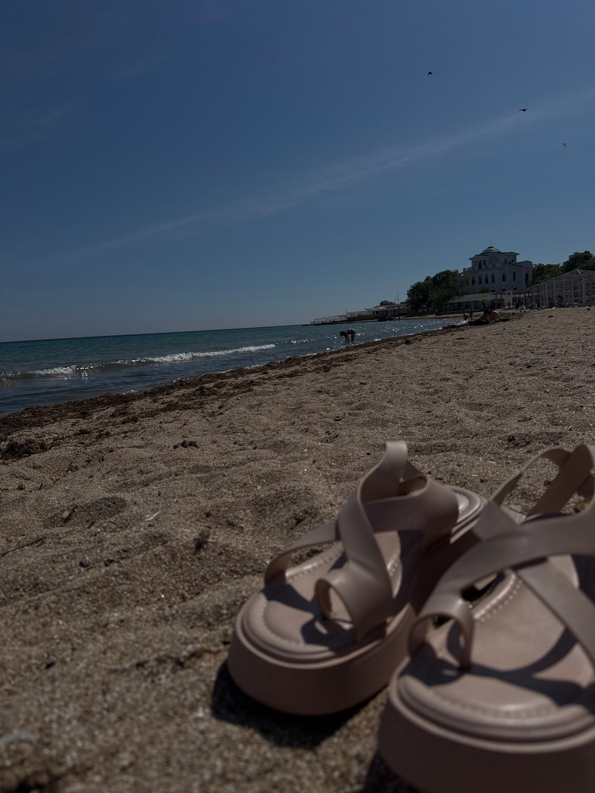 Woman enjoys quiet beach moment in Yevpatoriya, Ukraine