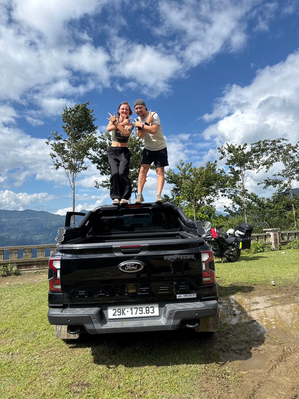 Couple poses on pickup truck at Tu Le scenic overlook
