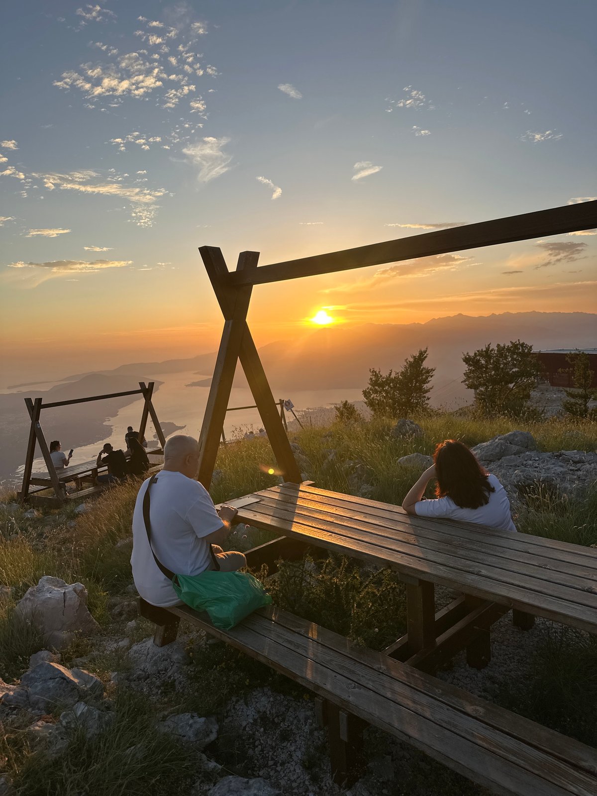 Couple watches sunset from mountain overlook in Montenegro