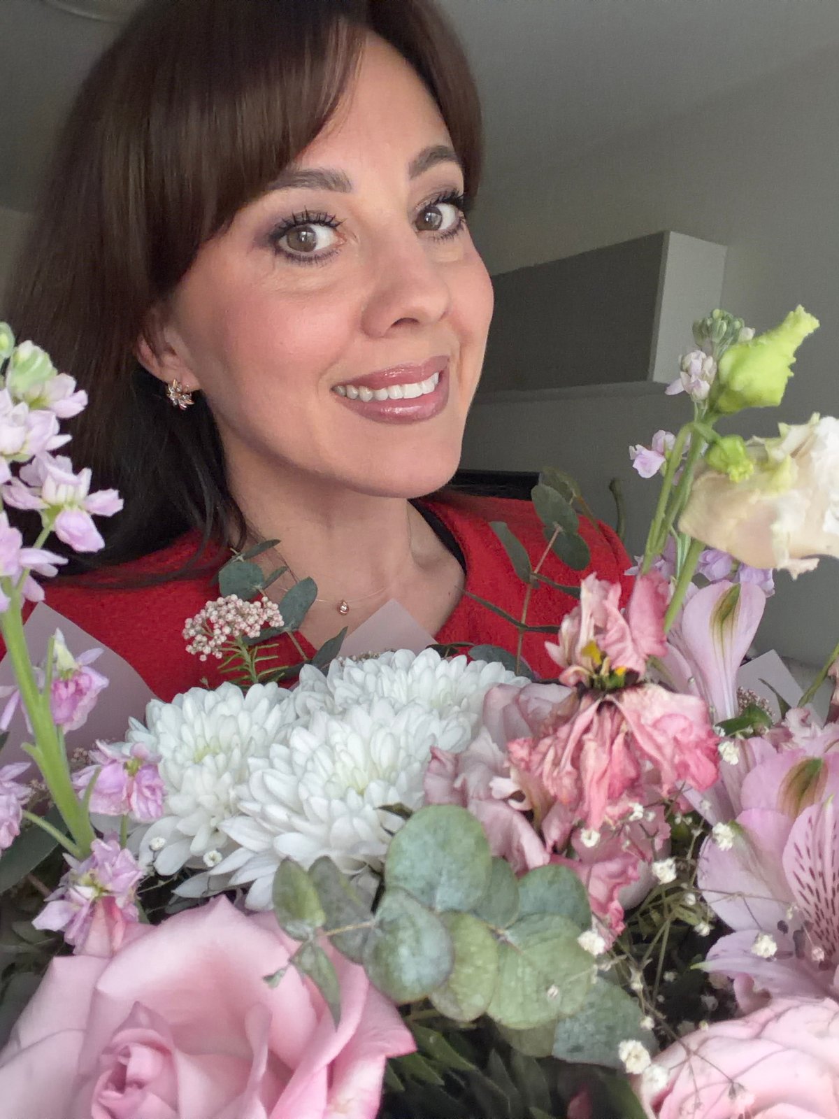 Woman poses with flowers, applies makeup in Riga afternoon