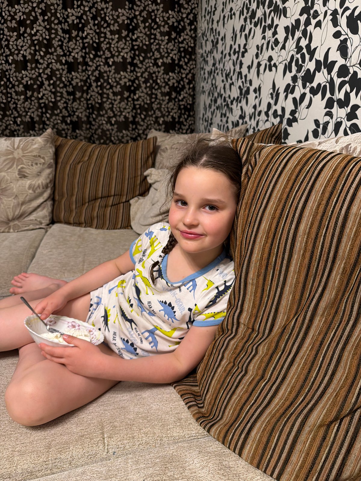 Child enjoys meal on couch in Russian home