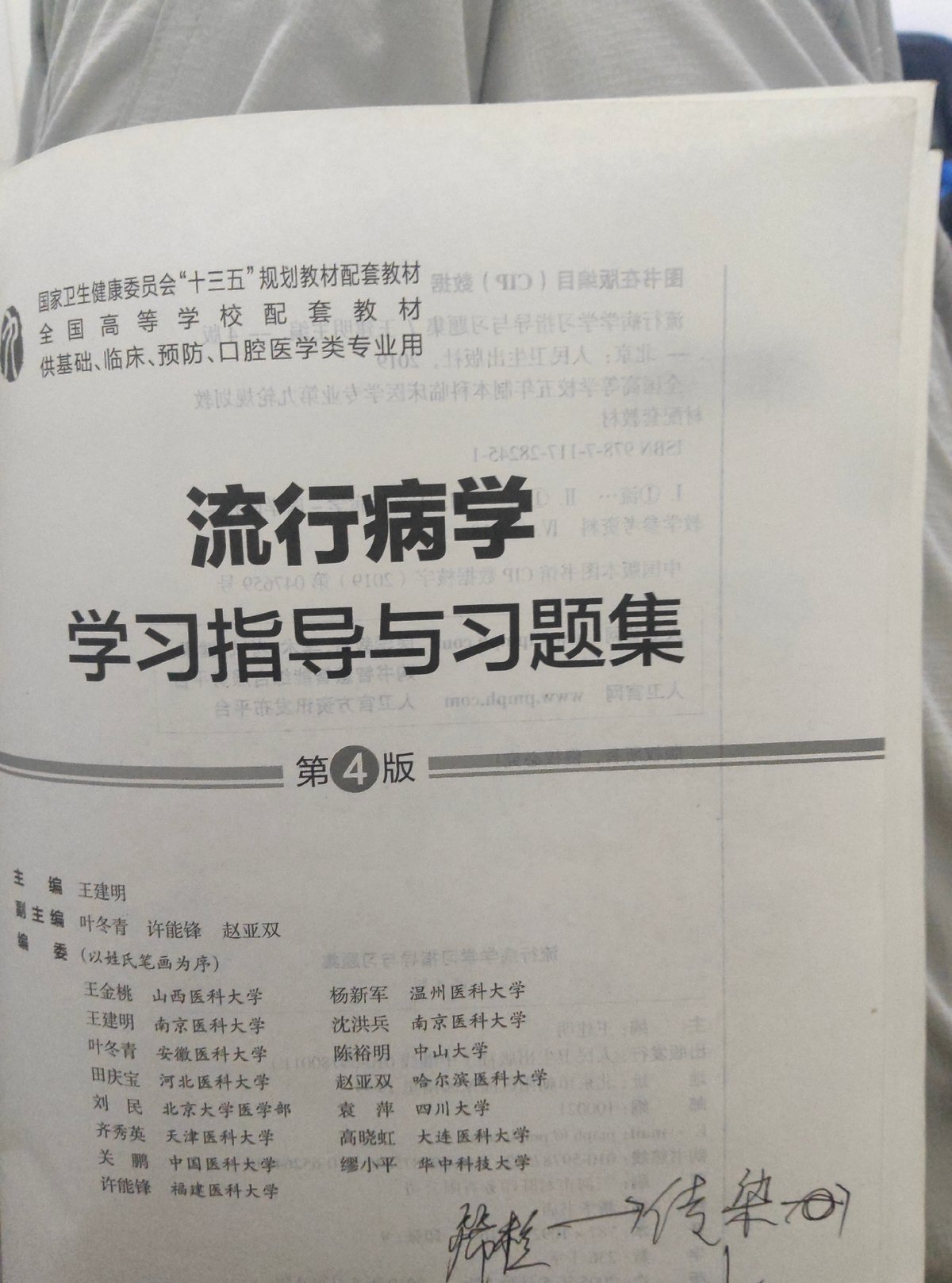 Student studies epidemiology textbooks in Chongqing dorm room
