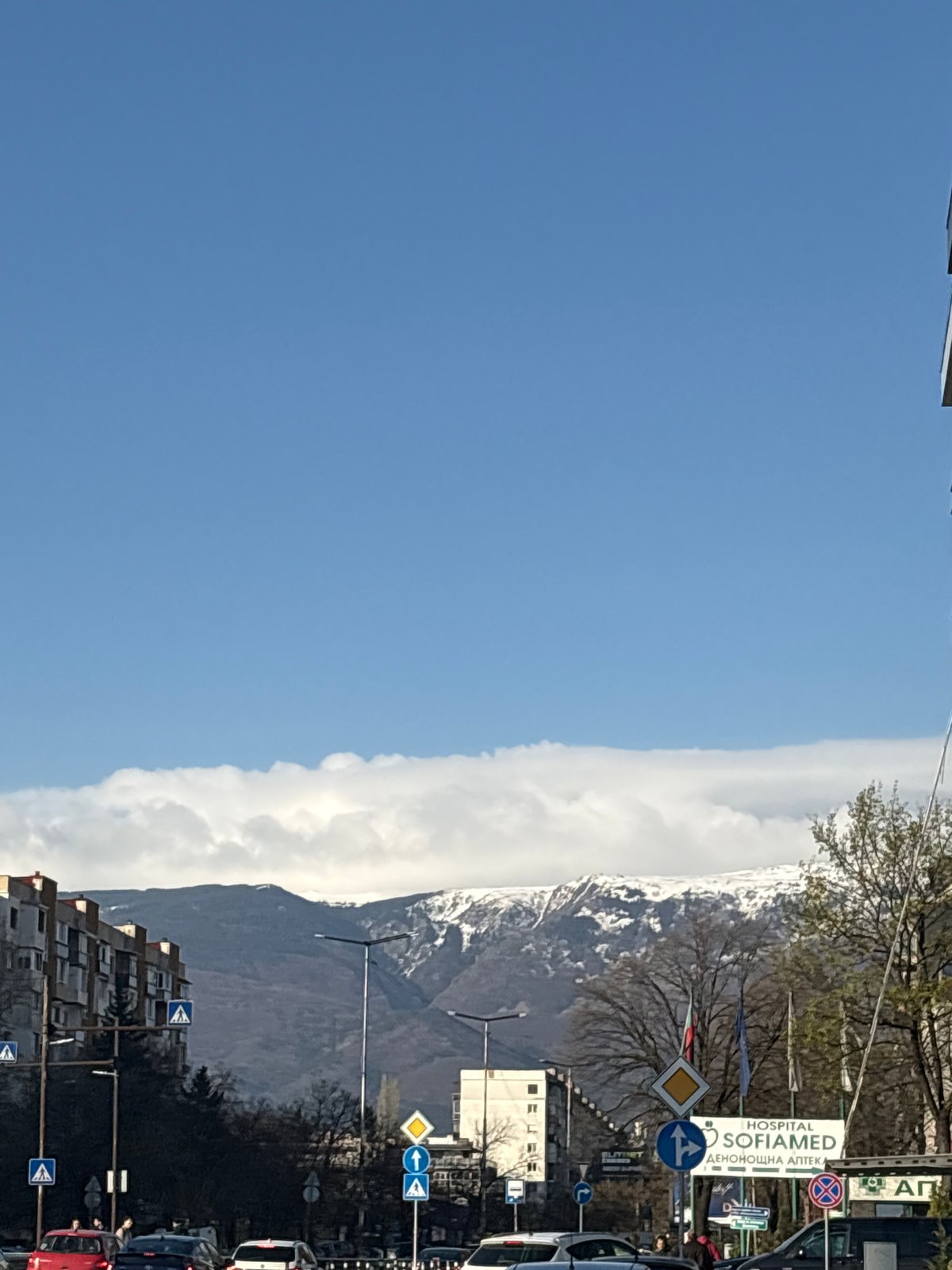 Mountain clouds blanket Sofia street scene with signage