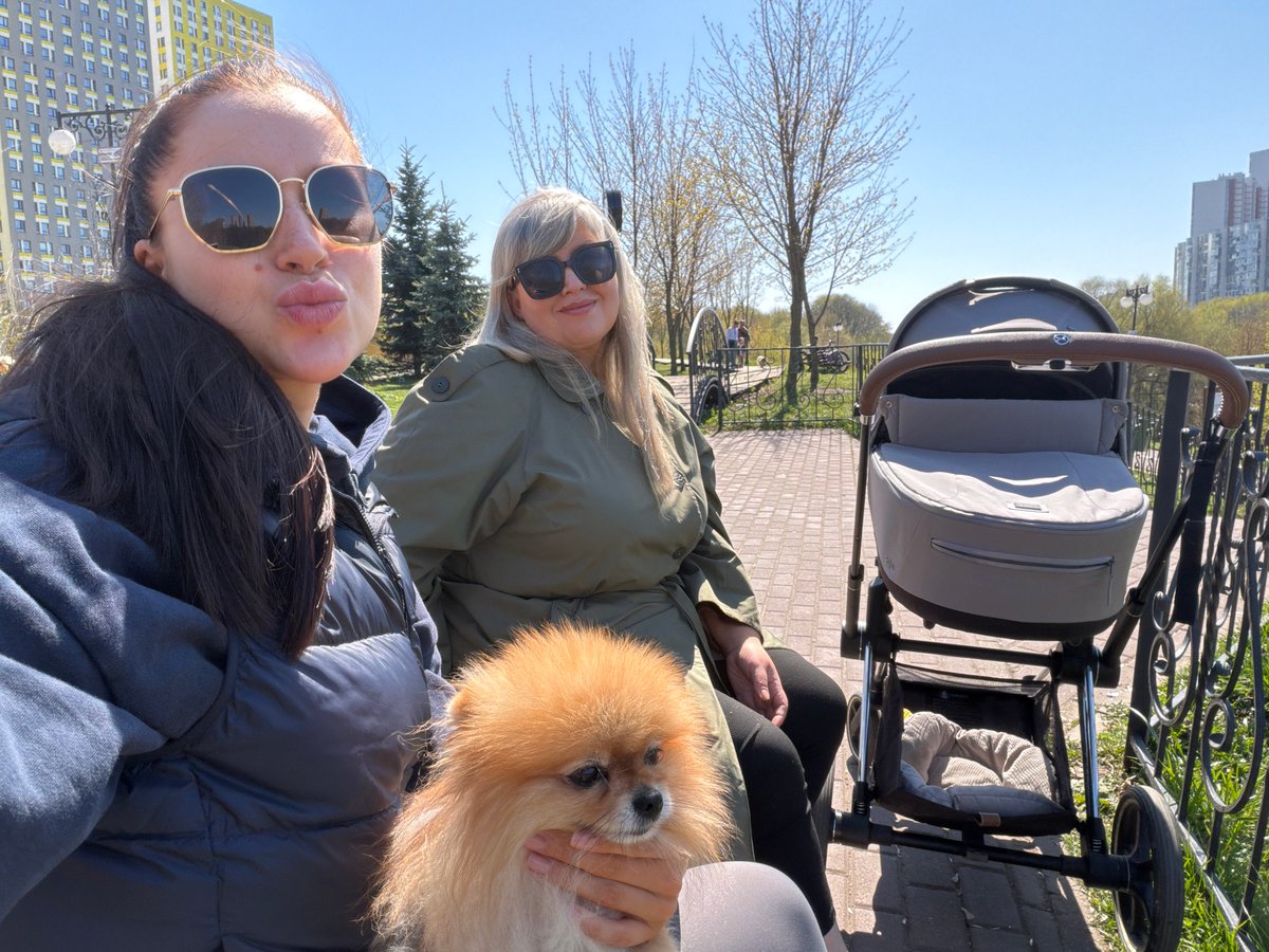 Women enjoy coffee and dog time near Moscow riverbank