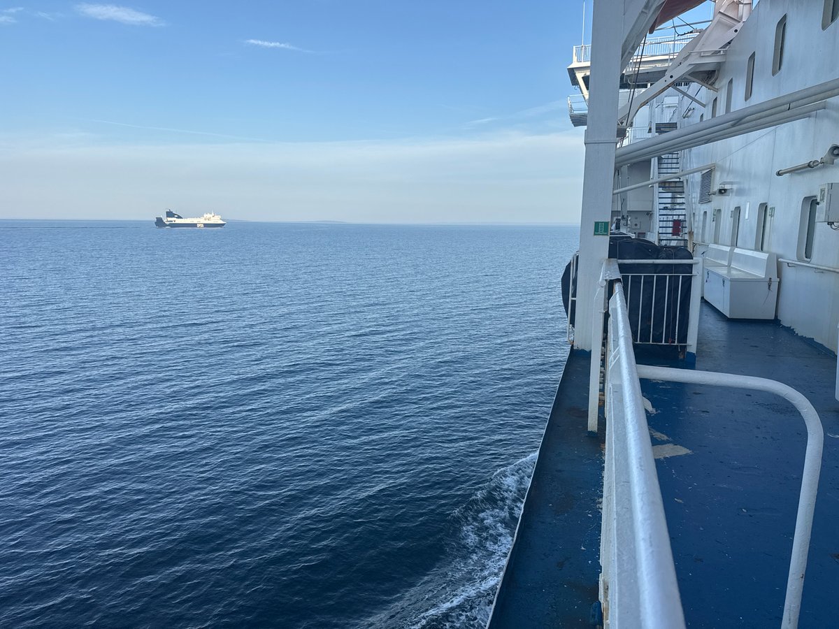 Two ferries share calm Swedish waters under a clear sky