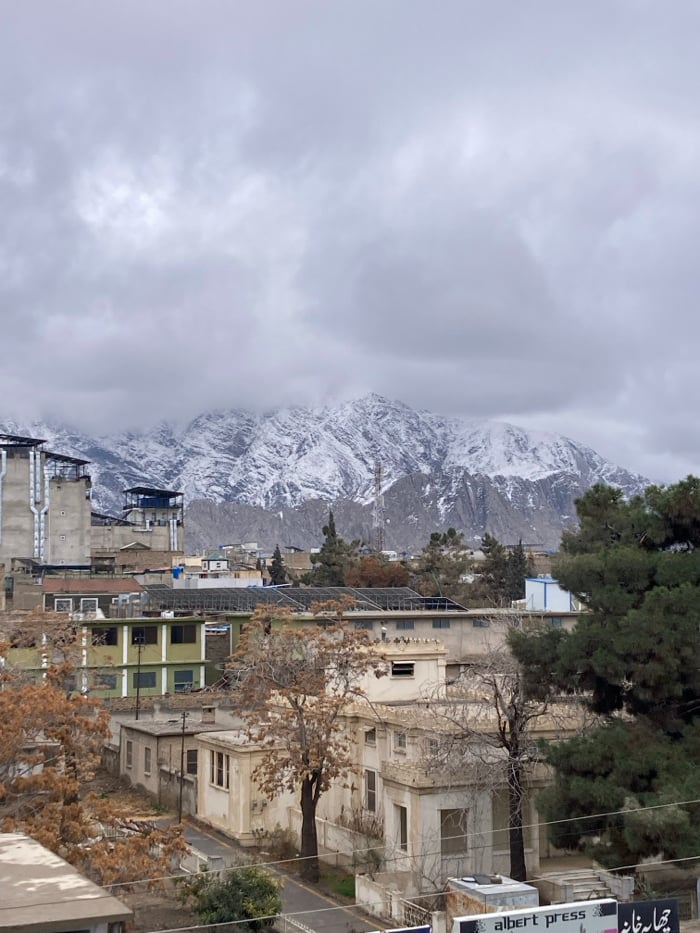 News crews broadcast from Quetta rooftops amid snowy mountain backdrop