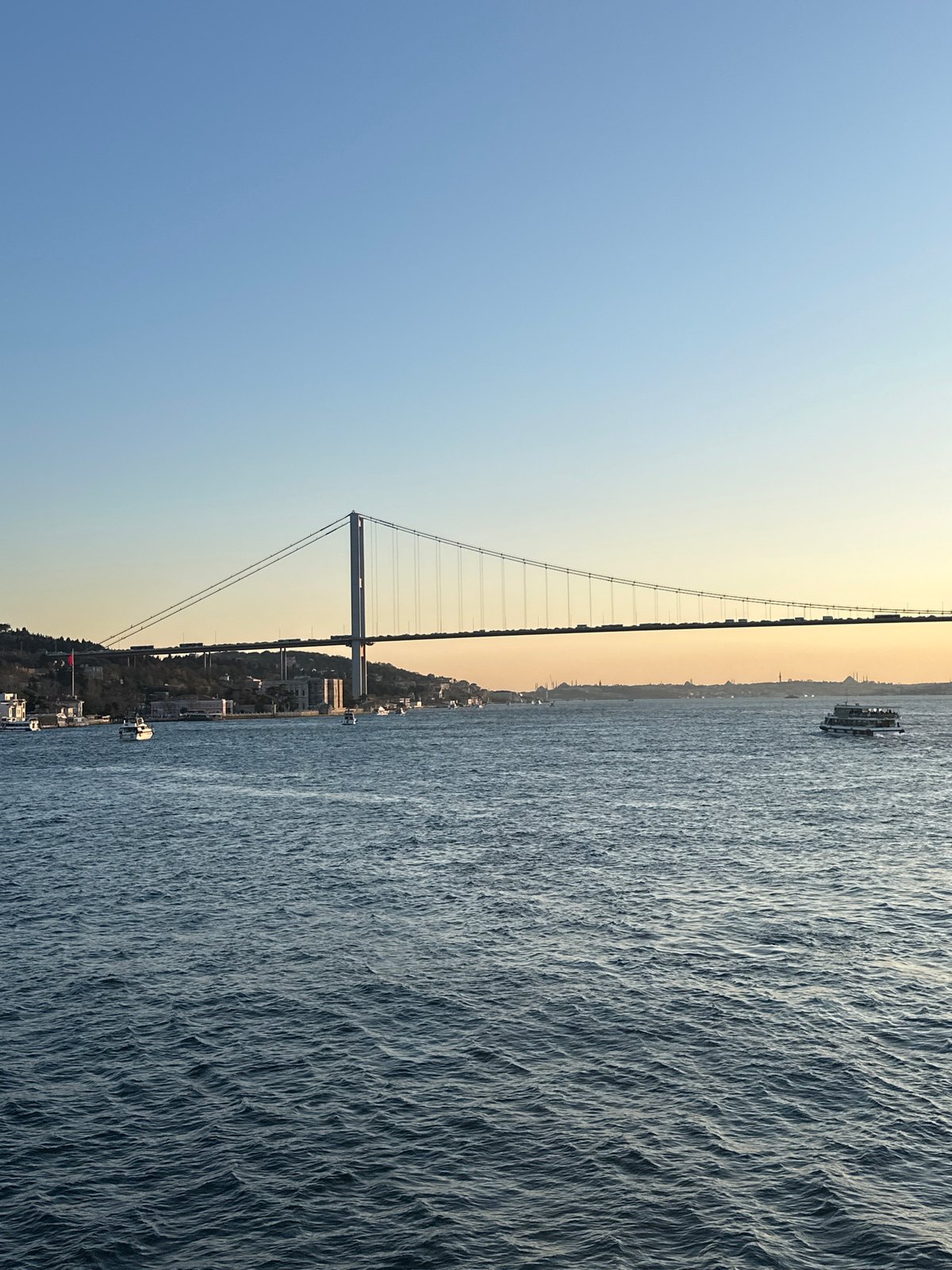 Bosphorus suspension bridge observed with boat traffic in Istanbul