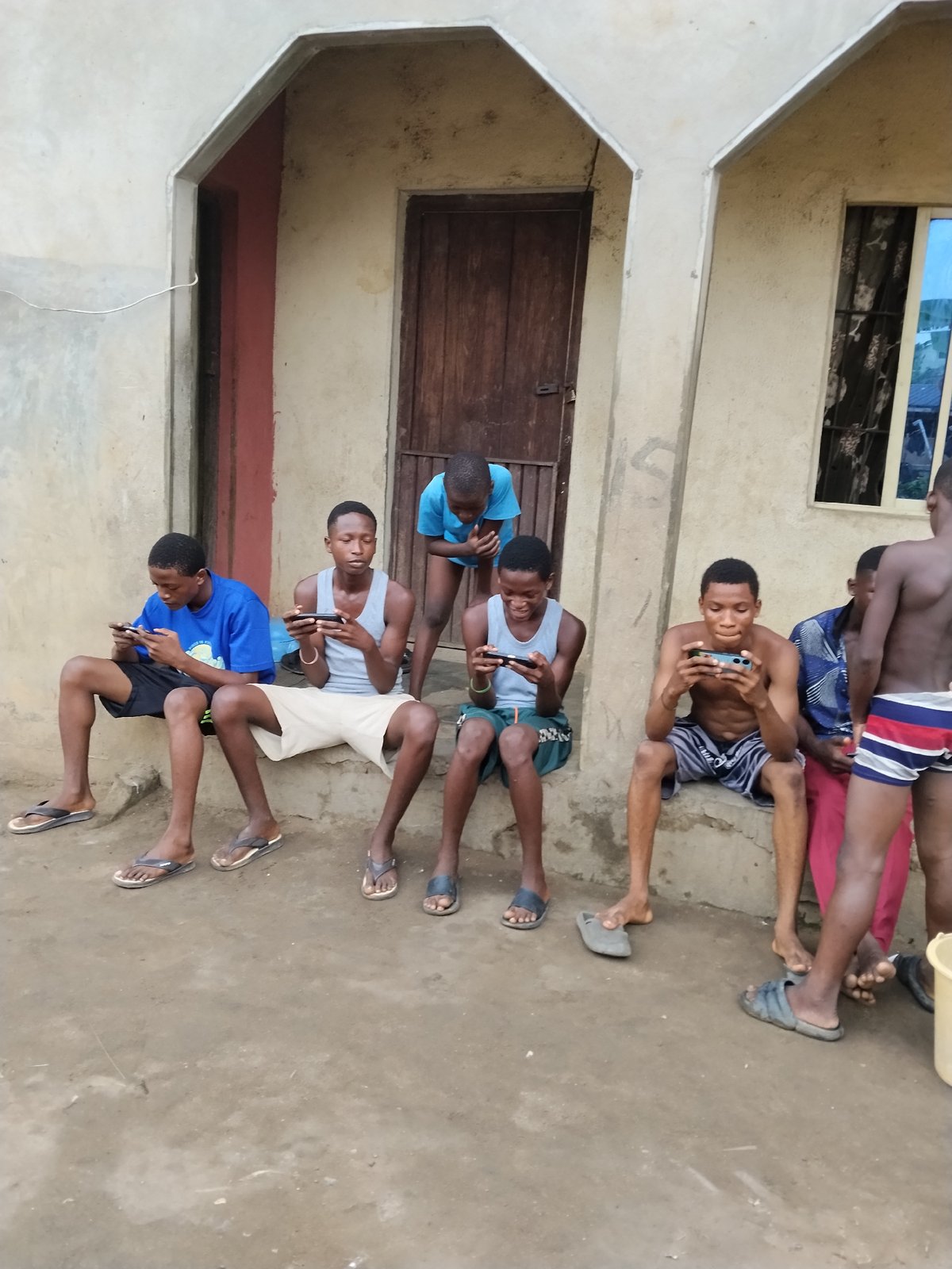 Young men gather on building steps in Aba, Nigeria