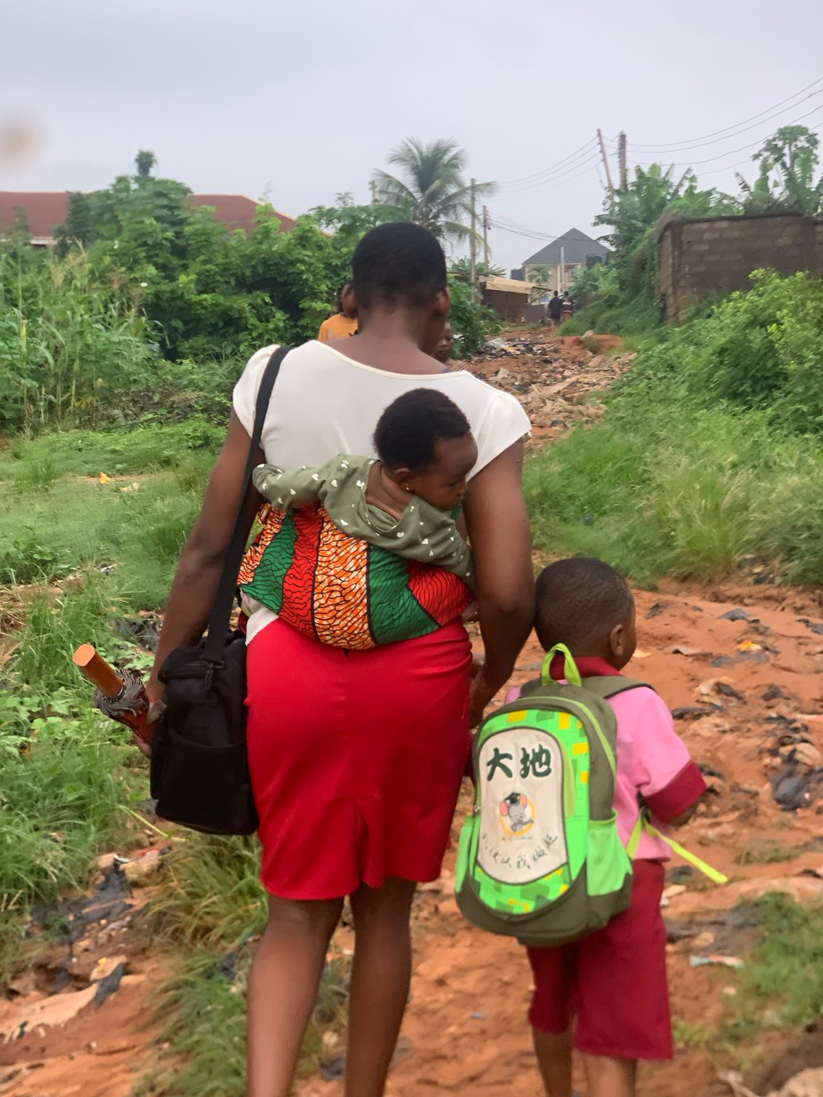 Morning foot traffic along a dirt road in Ukwu-Abwa, Nigeria