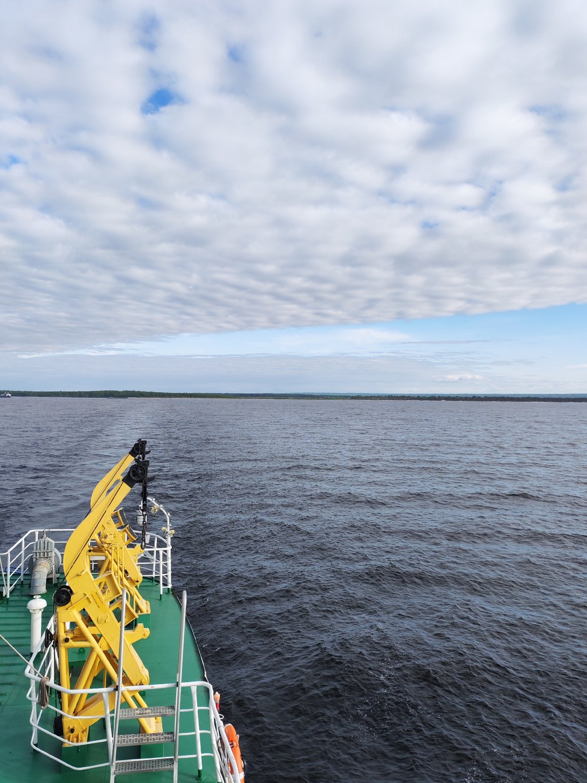 Boat passenger documents cloudy skies, rainbow effects in Ozernoe Ust'e
