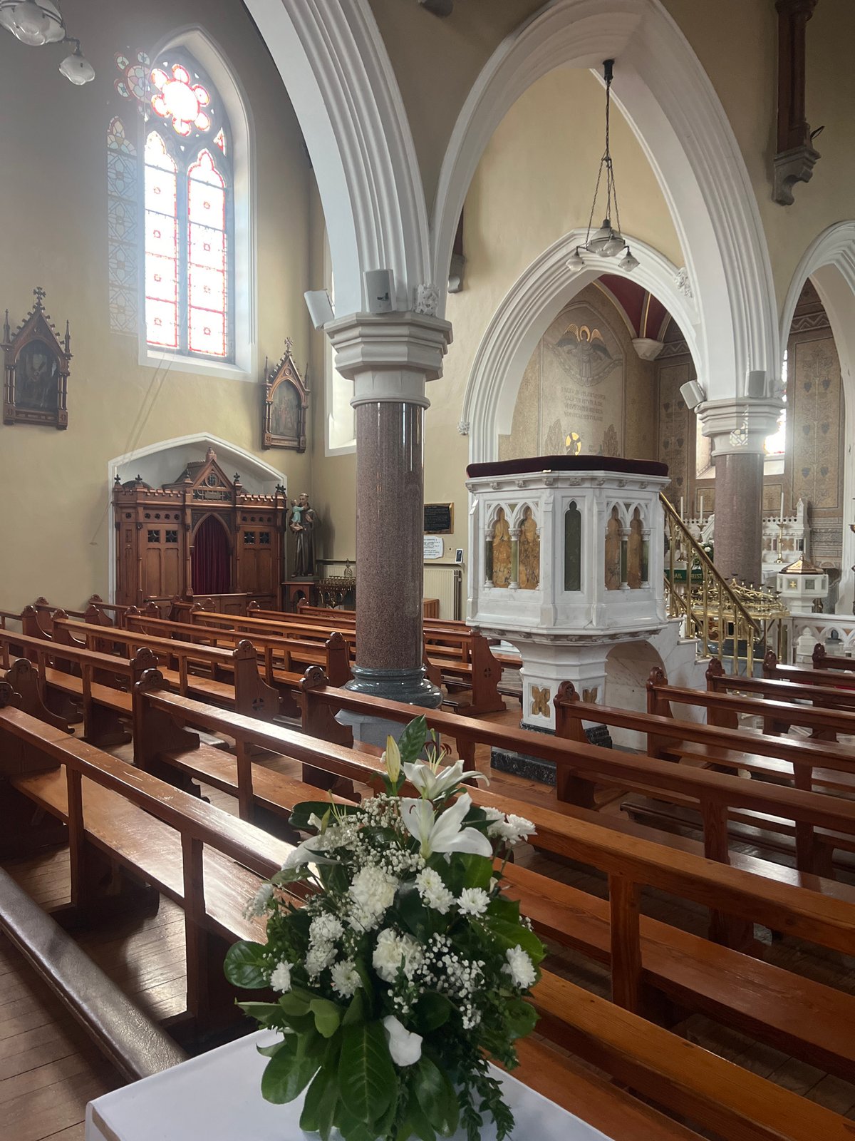 Church interior and florals, likely a memorial service