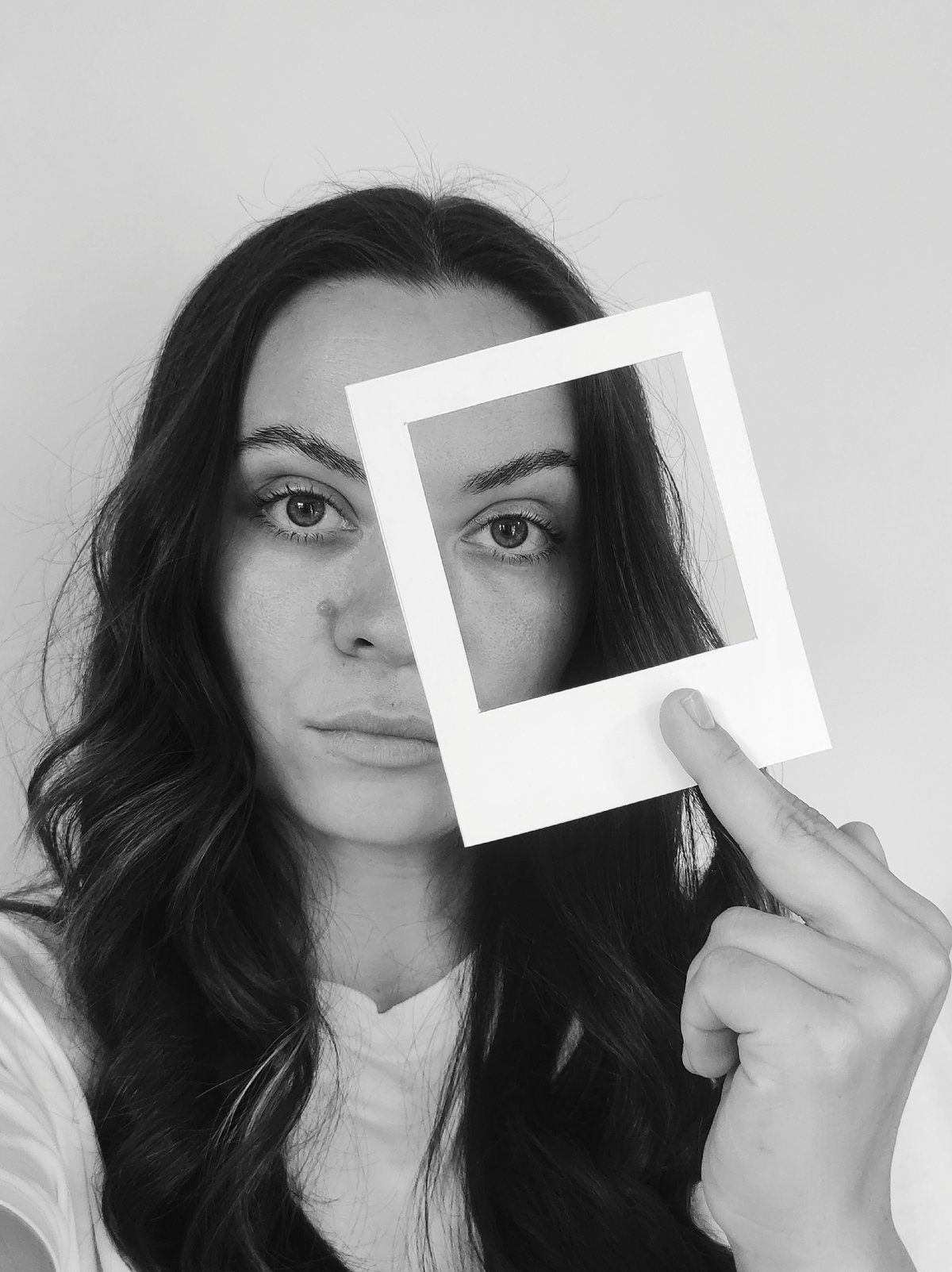 Woman photographed in artistic close-up portrait session with frame prop