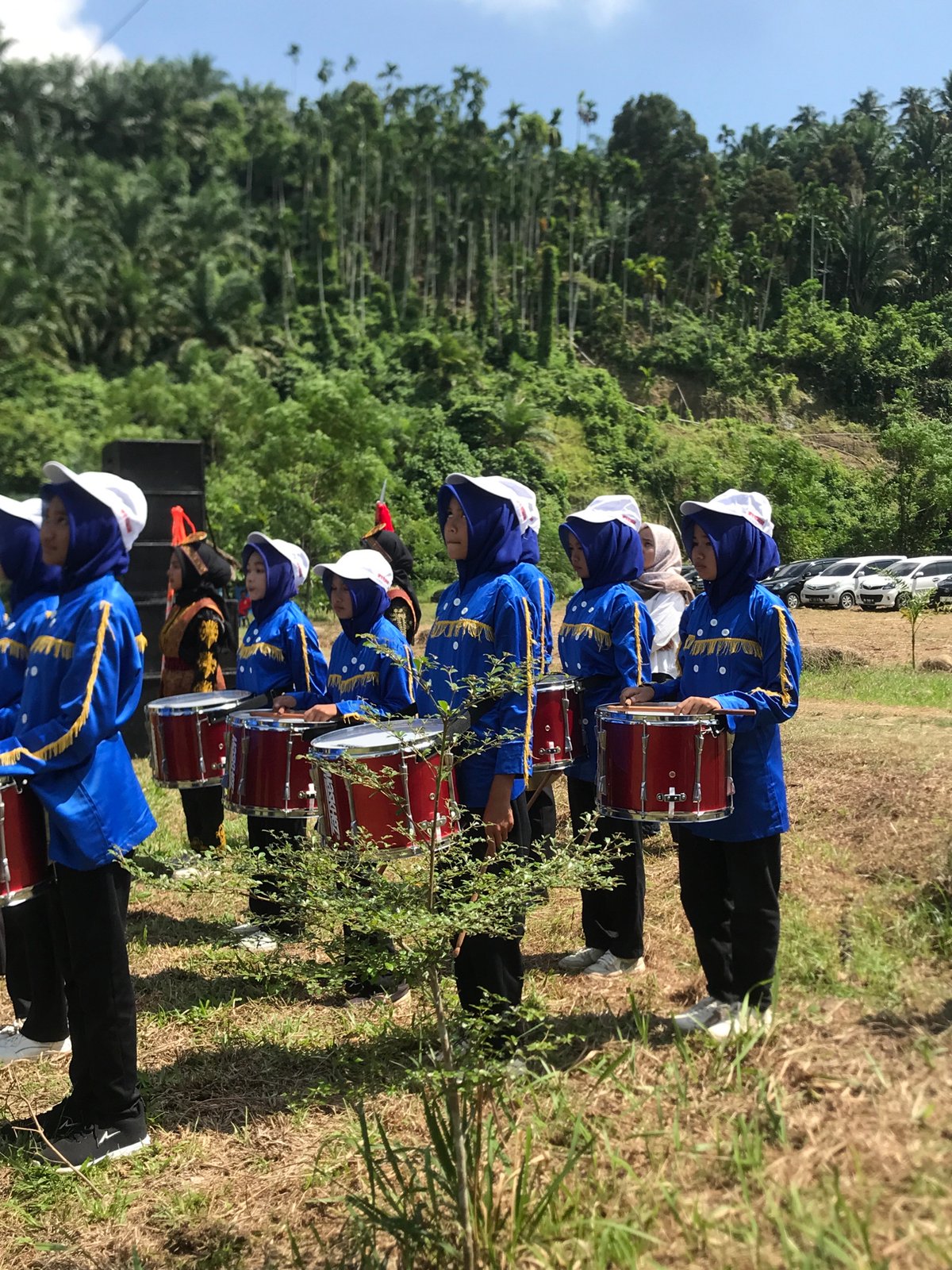 Marching band performs drumline routine at outdoor event in Langkuta