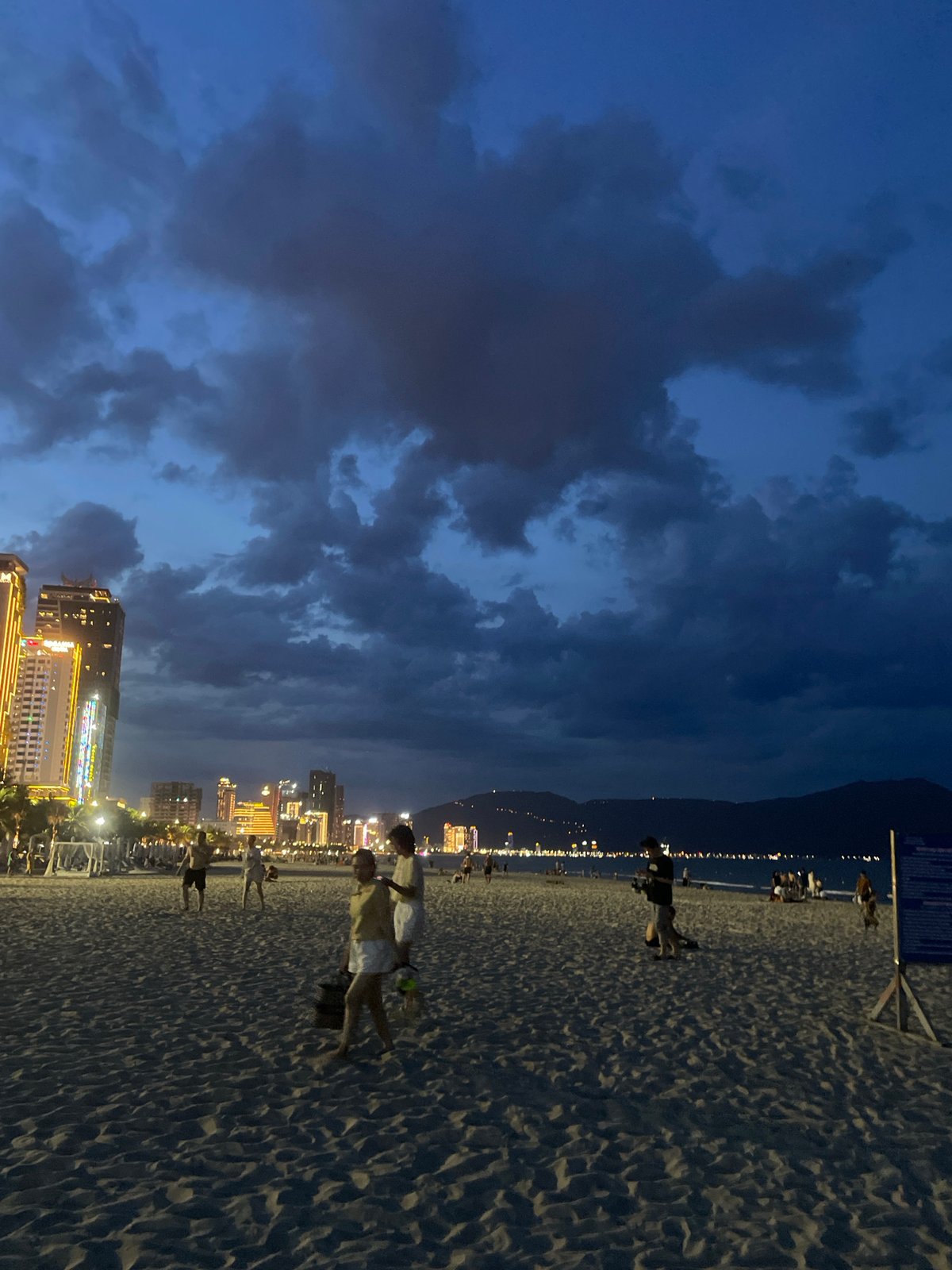 Da Nang beach at dusk, parasailing and city lights