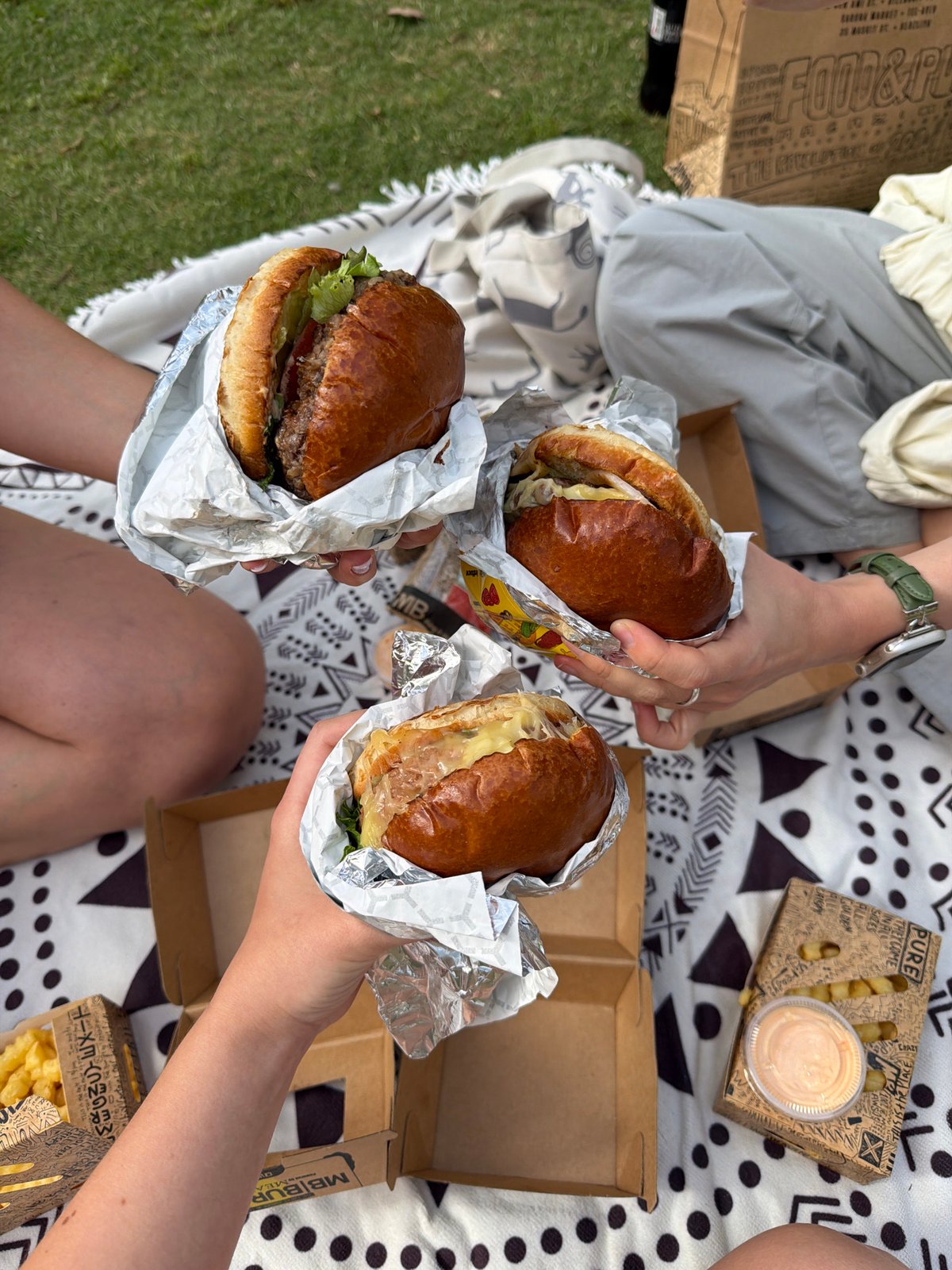 Three people enjoy afternoon picnic in Tel Aviv park