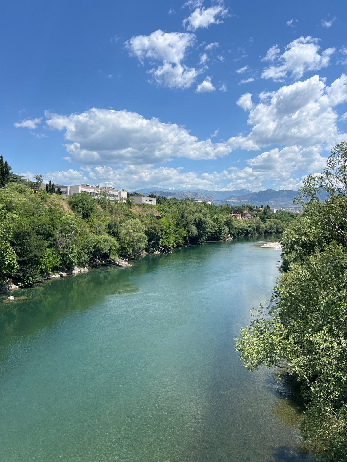 Summer morning along Podgorica's river, cafés, and blooming streets