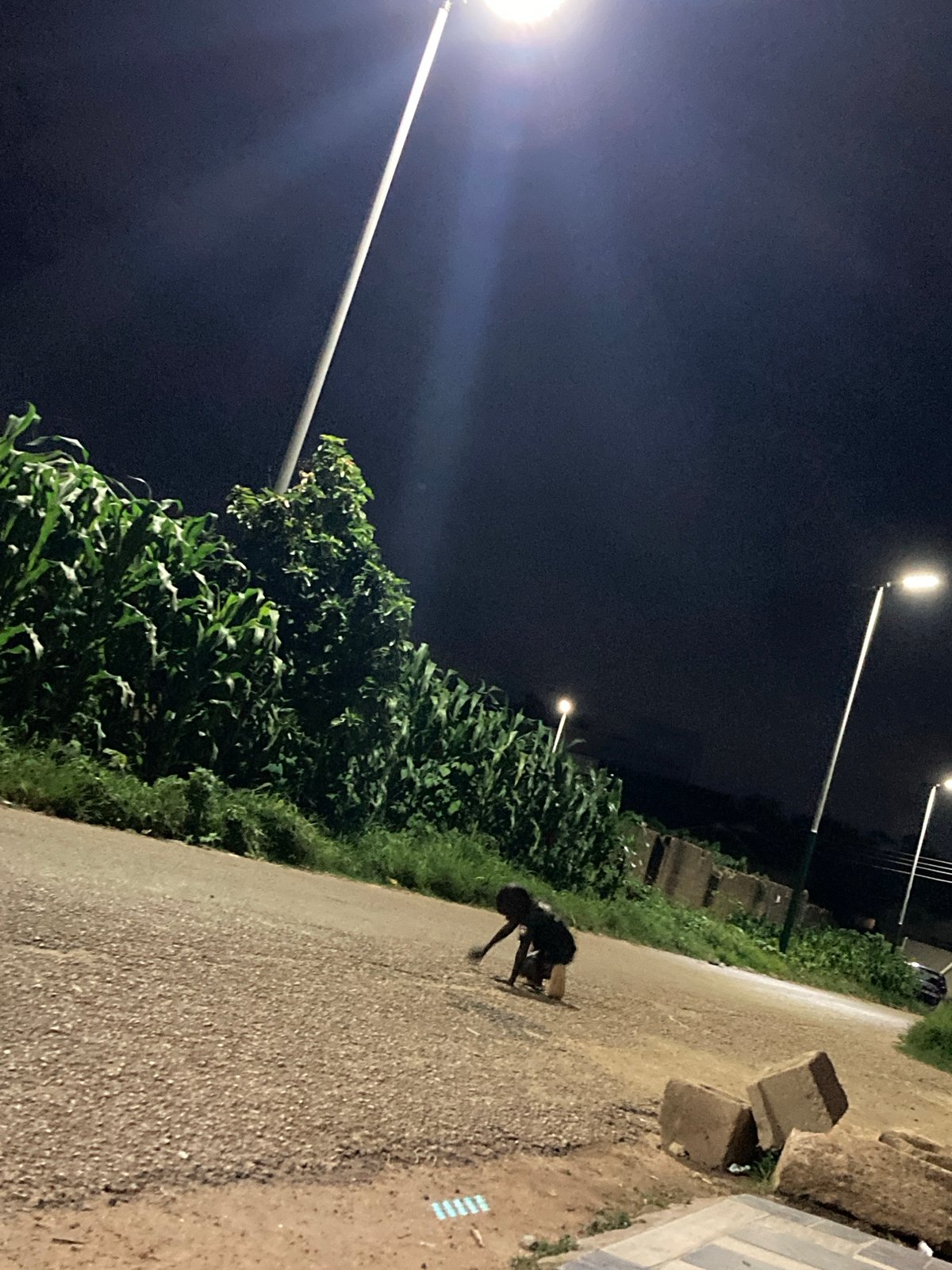 Pickup football on a dusty Jos pitch under stormy skies