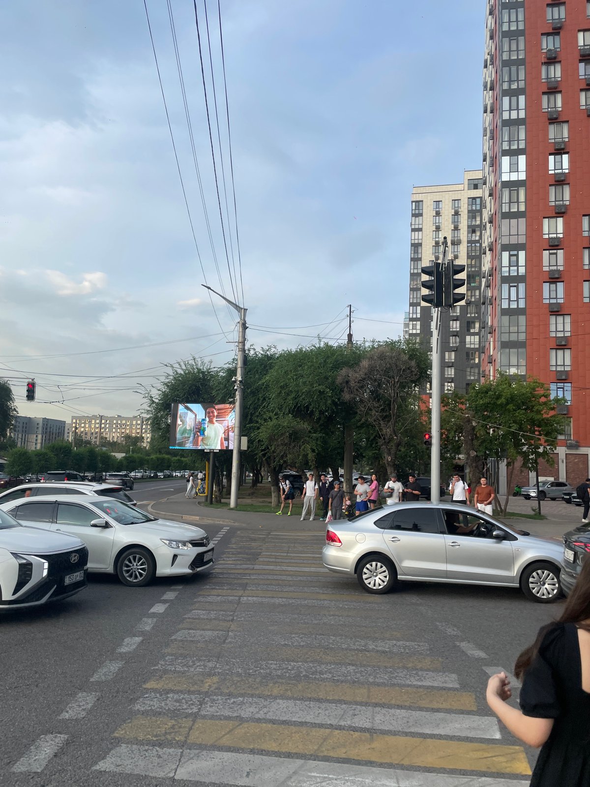 Almaty evening traffic and urban streets under stormy skies