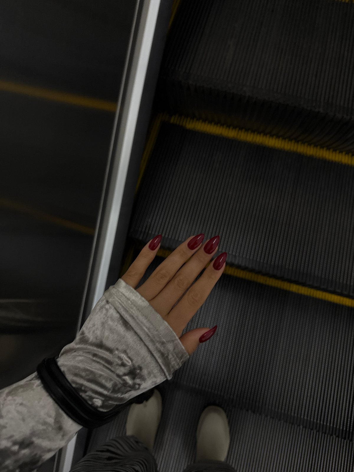 Person with burgundy nails rides escalator in Yerevan