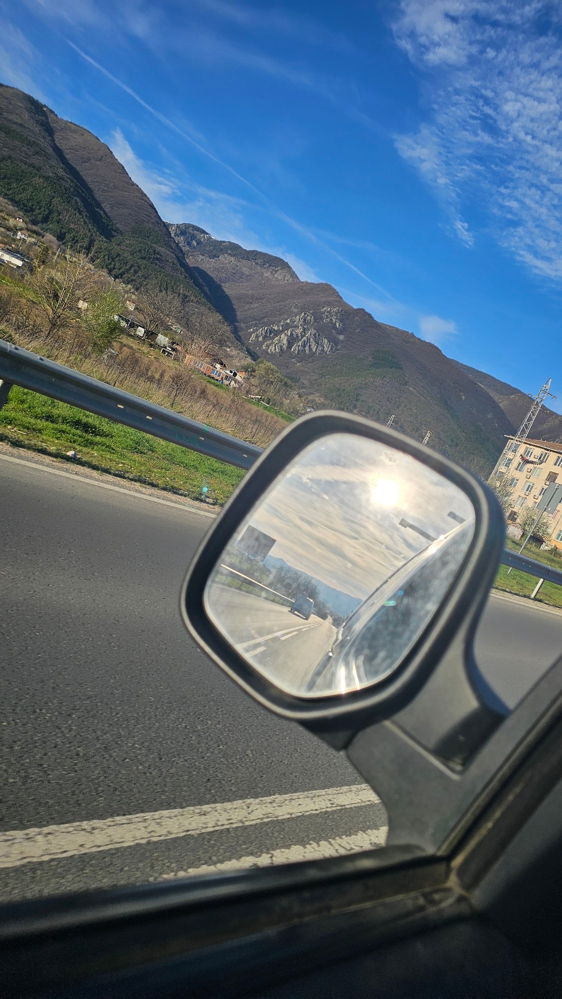 Highway travel documented through side mirror in Sopot, Bulgaria