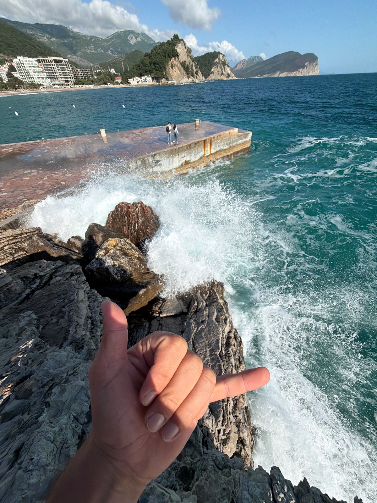 Tourist documents seaside day in Petrovac, Montenegro with selfies