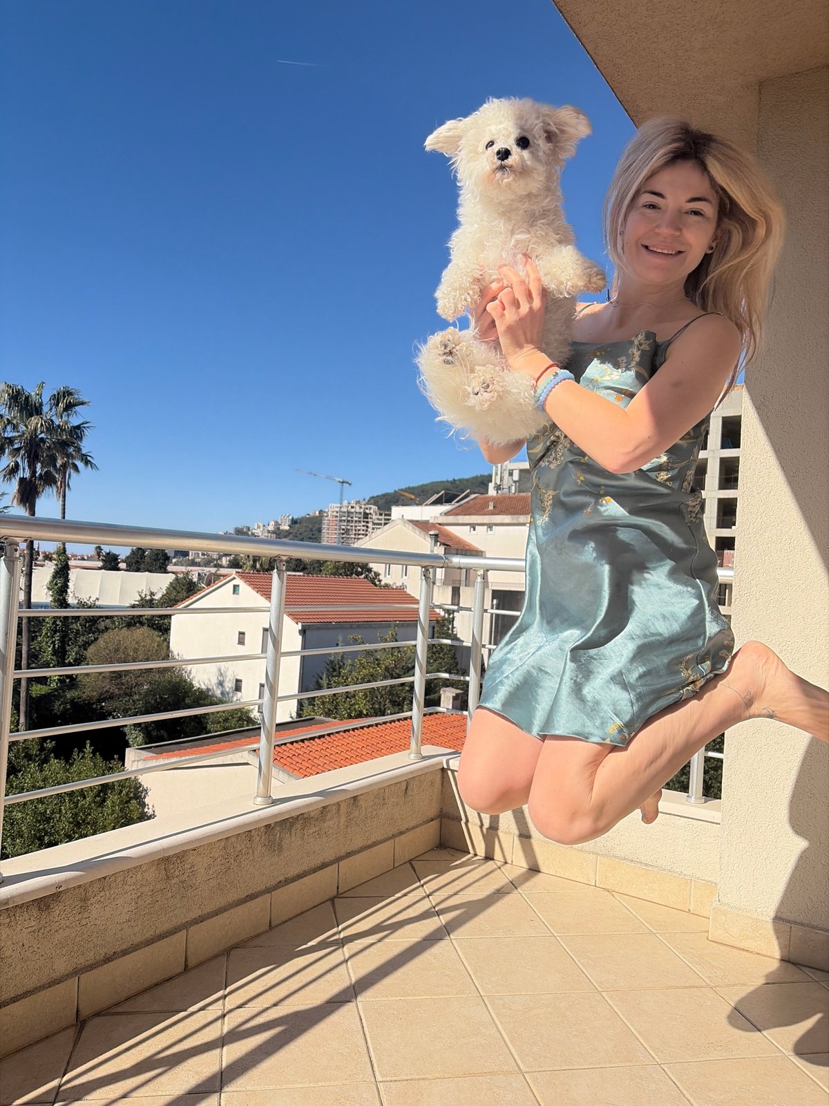 Woman with dog enjoys morning moment on Budva balcony