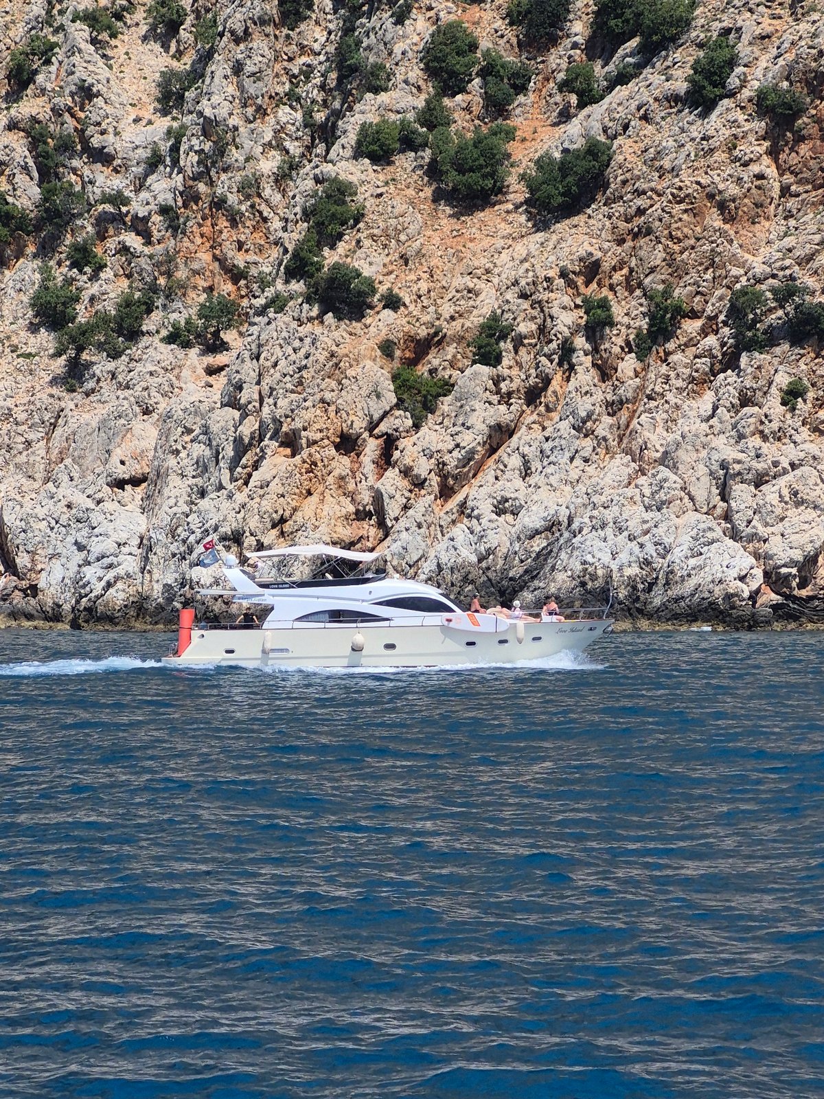 Tourist boat cruises near Alanya Castle cliffs, Turkey