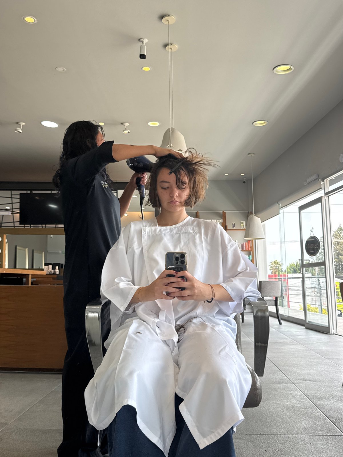 Woman takes selfie during hair appointment in Puebla salon