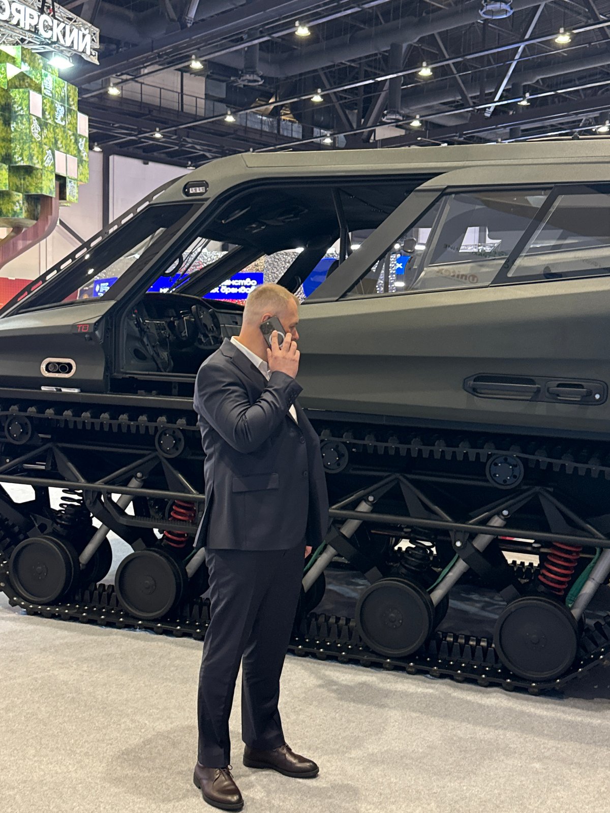 Man takes phone call beside tracked vehicle in Pushkin
