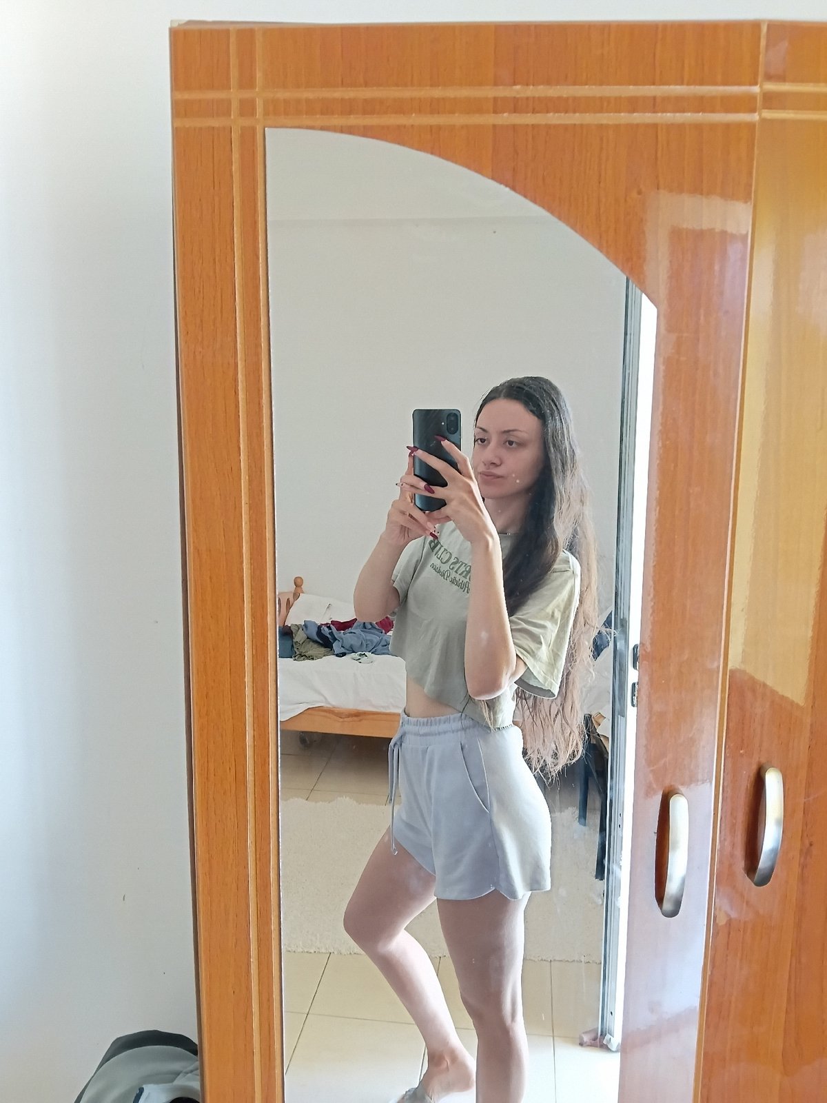 Woman takes mirror selfies in Vlora, Albania bedroom