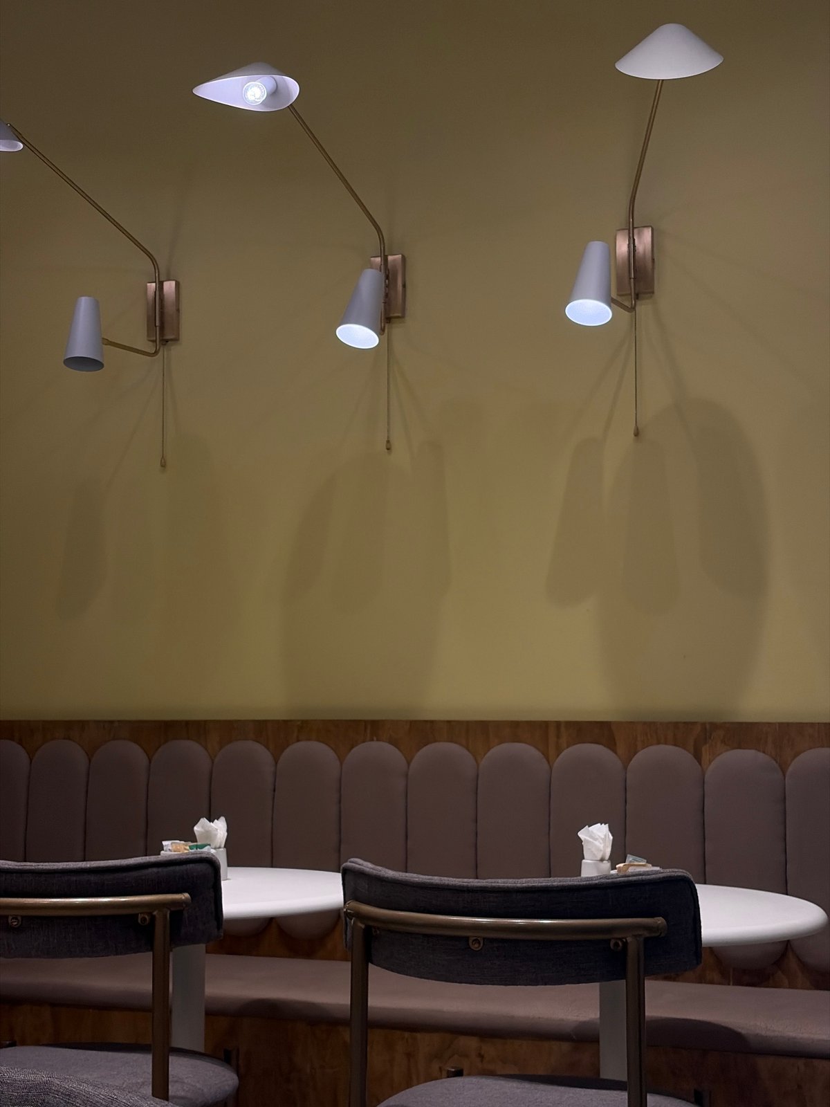 Indoor scene features wall lamps and red rose arrangements