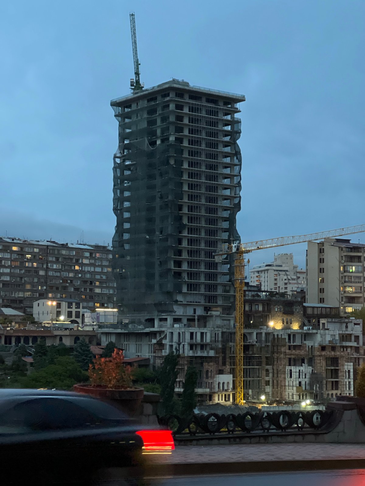 Evening life documented across Yerevan featuring billboards, landmarks, stray cat