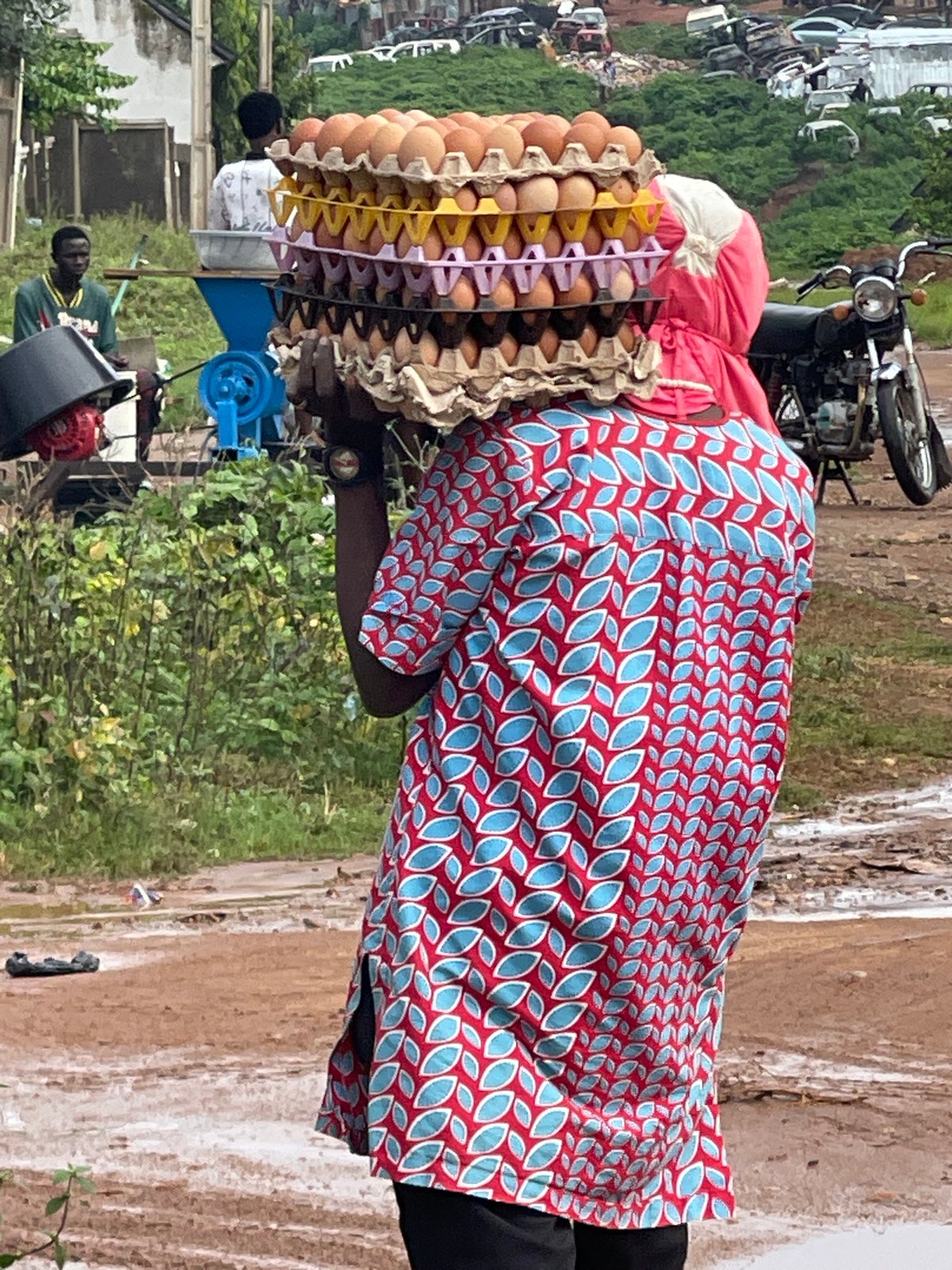Stacked egg cartons balanced overhead on an Abuja street