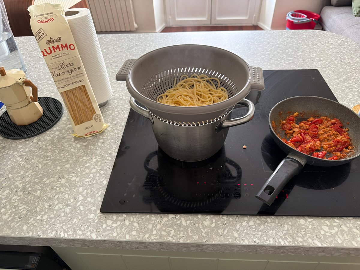 Spaghetti draining on a Milan kitchen cooktop