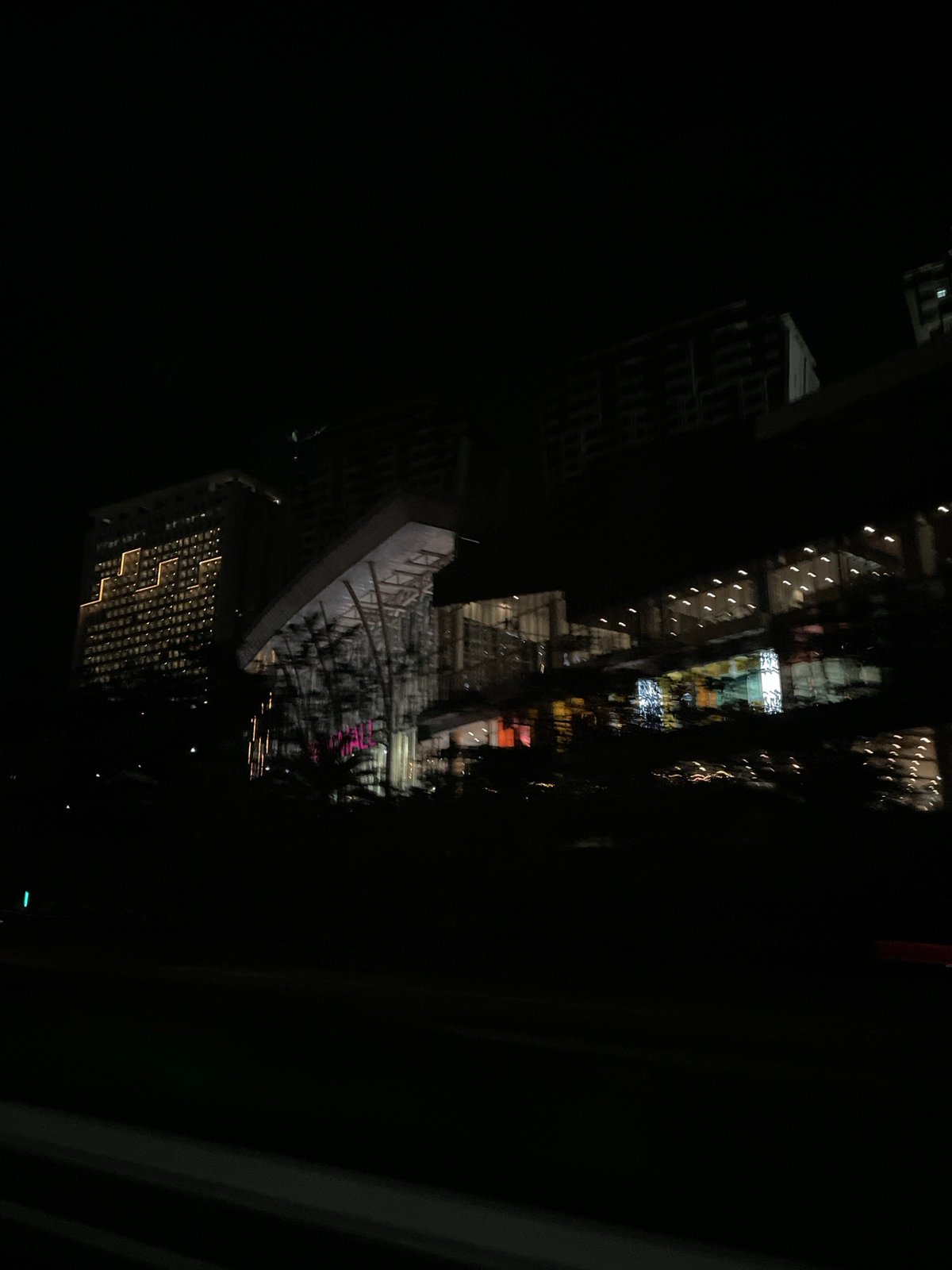 Illuminated shopping mall observed at night in Babakan Madang