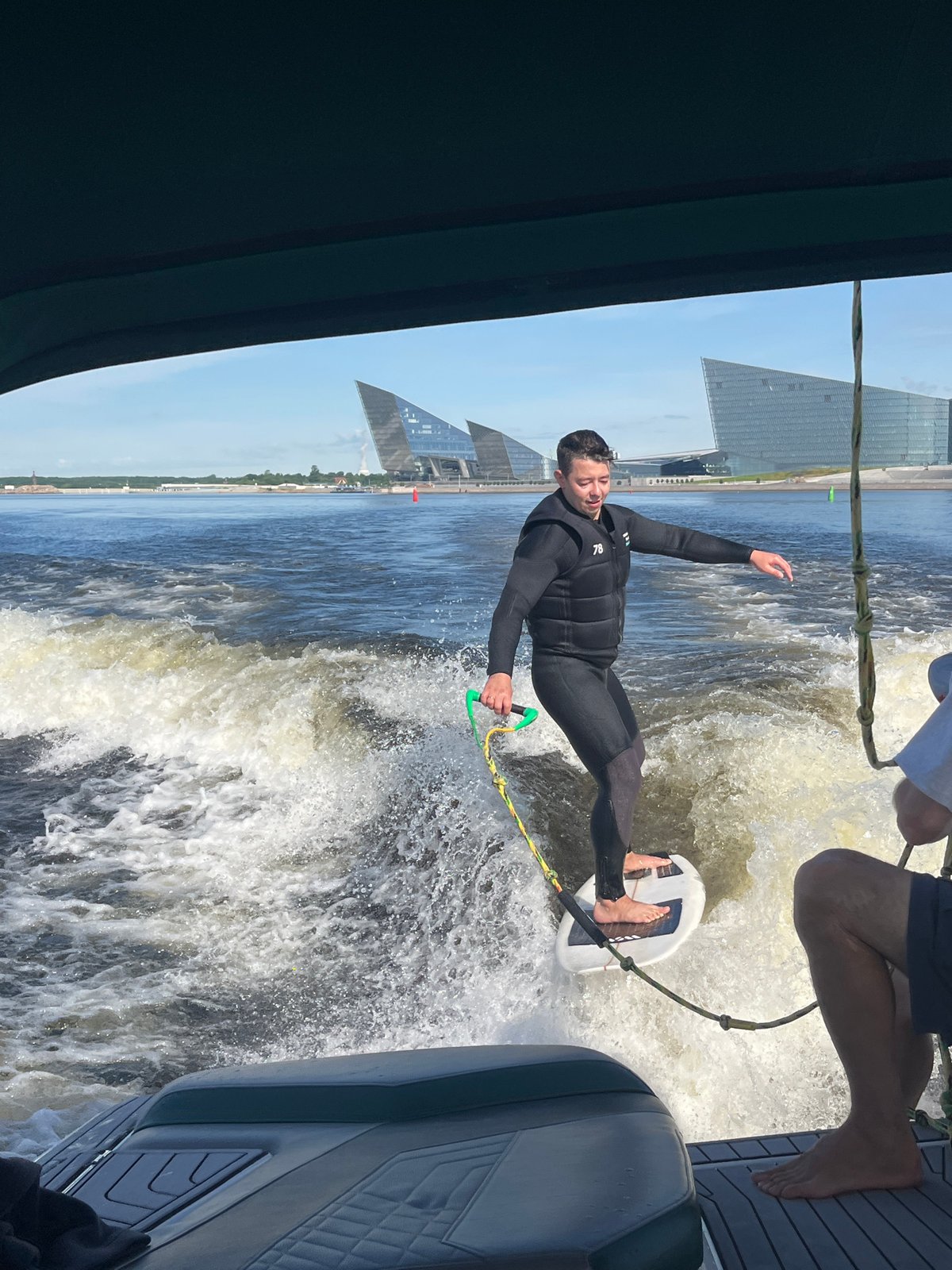 Wake surfing behind a boat on the Neva River