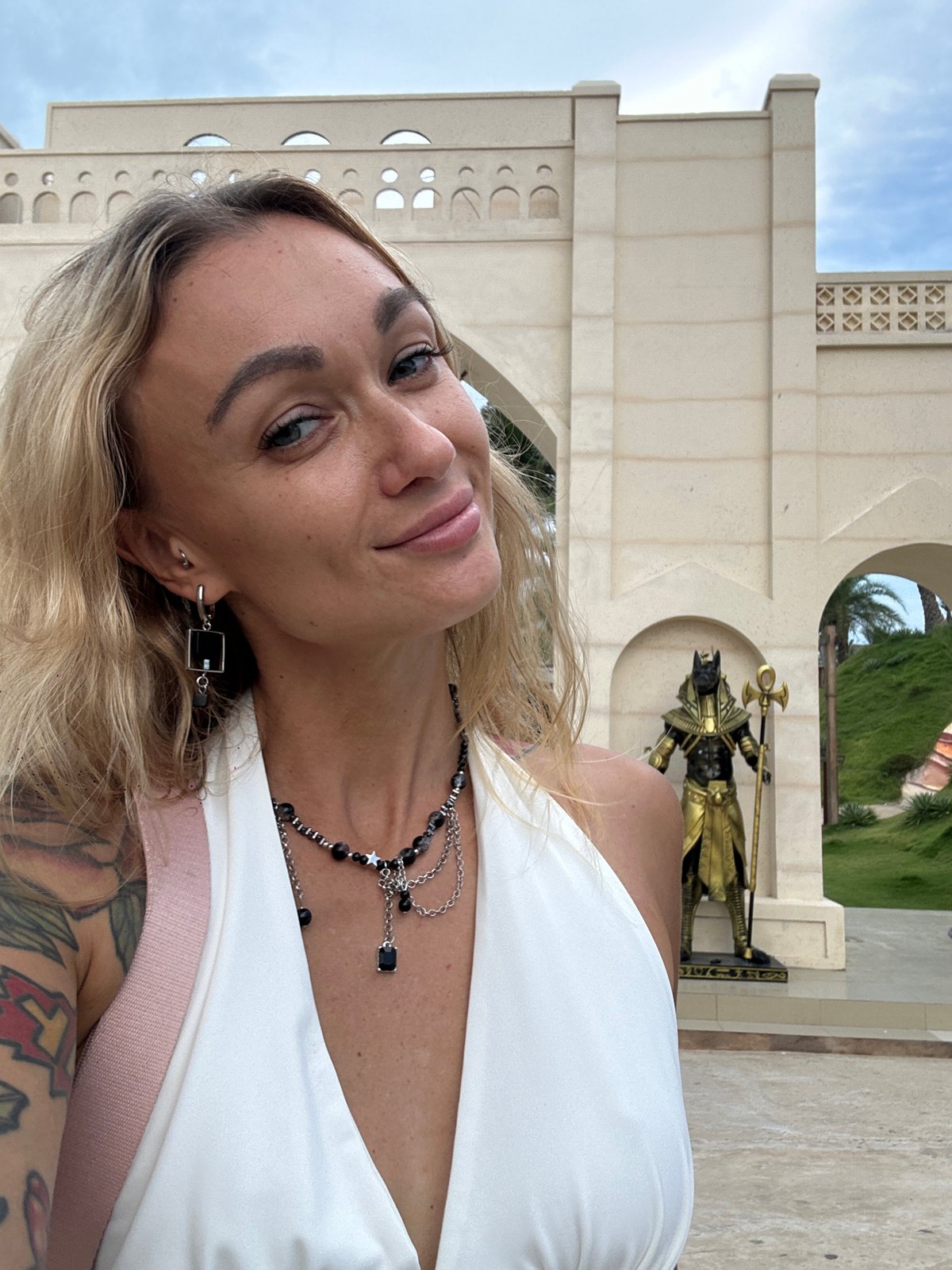Tourist photographs herself at Egyptian-themed archway in Mũi Né