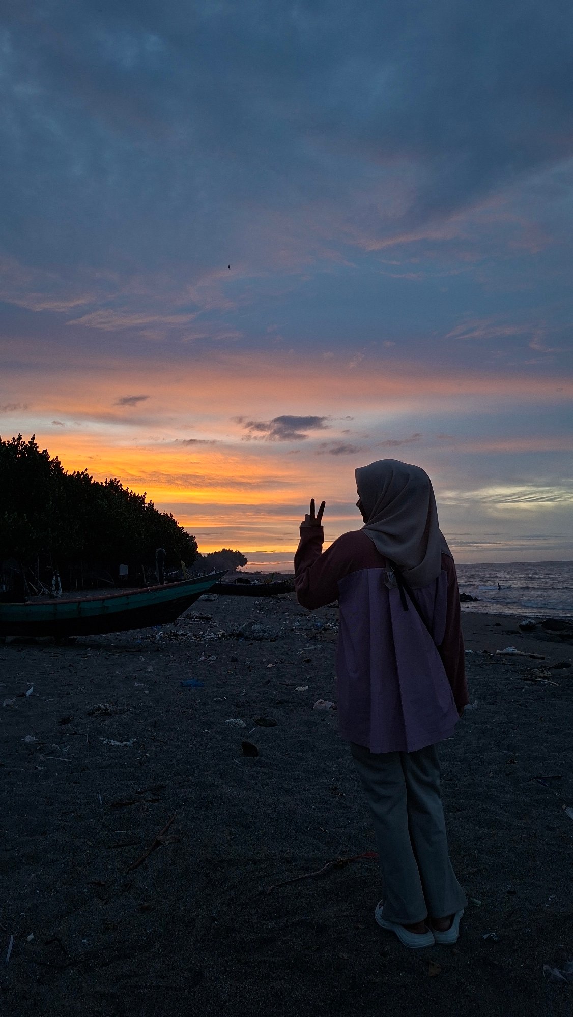 Lhokseumawe beach at golden hour, cargo ship on the horizon