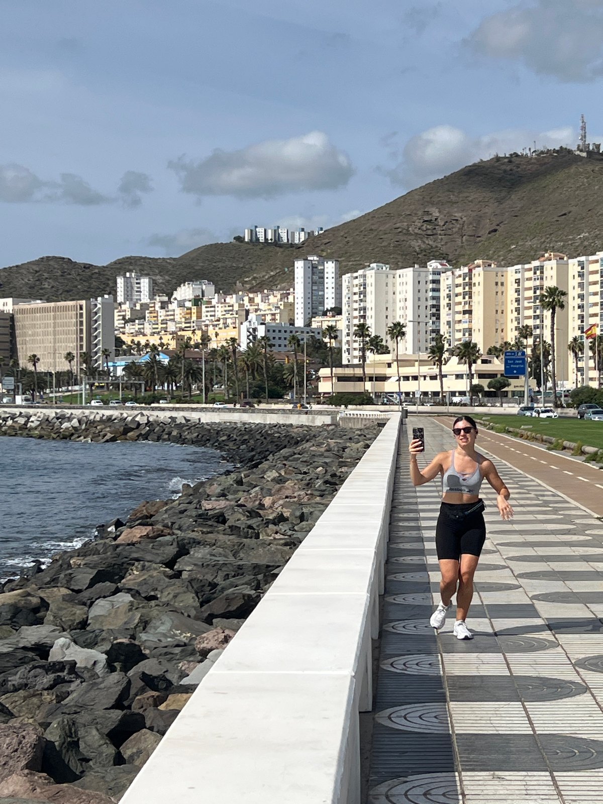 Woman takes selfies along Las Palmas waterfront walkway