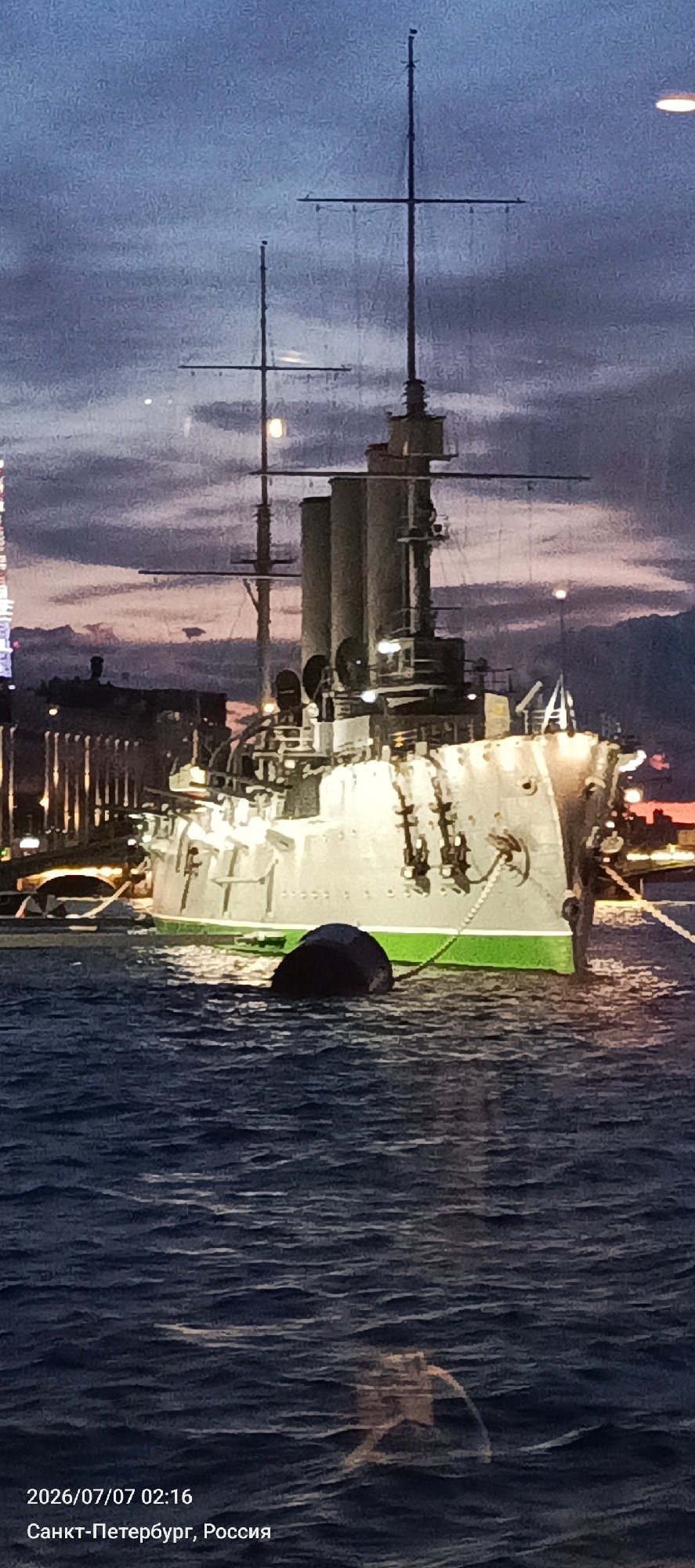 Aurora cruiser and Trinity Bridge lit up at twilight, Saint Petersburg