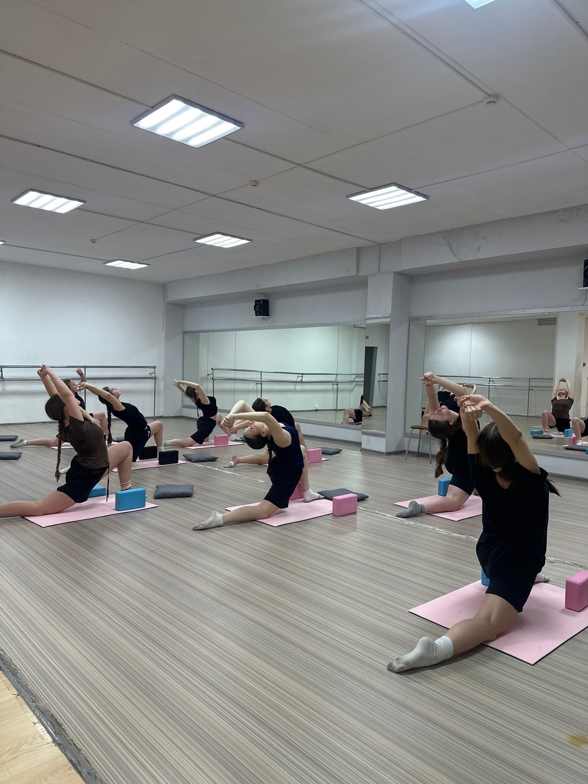 Three dancers perform synchronized leap in Votkinsk studio
