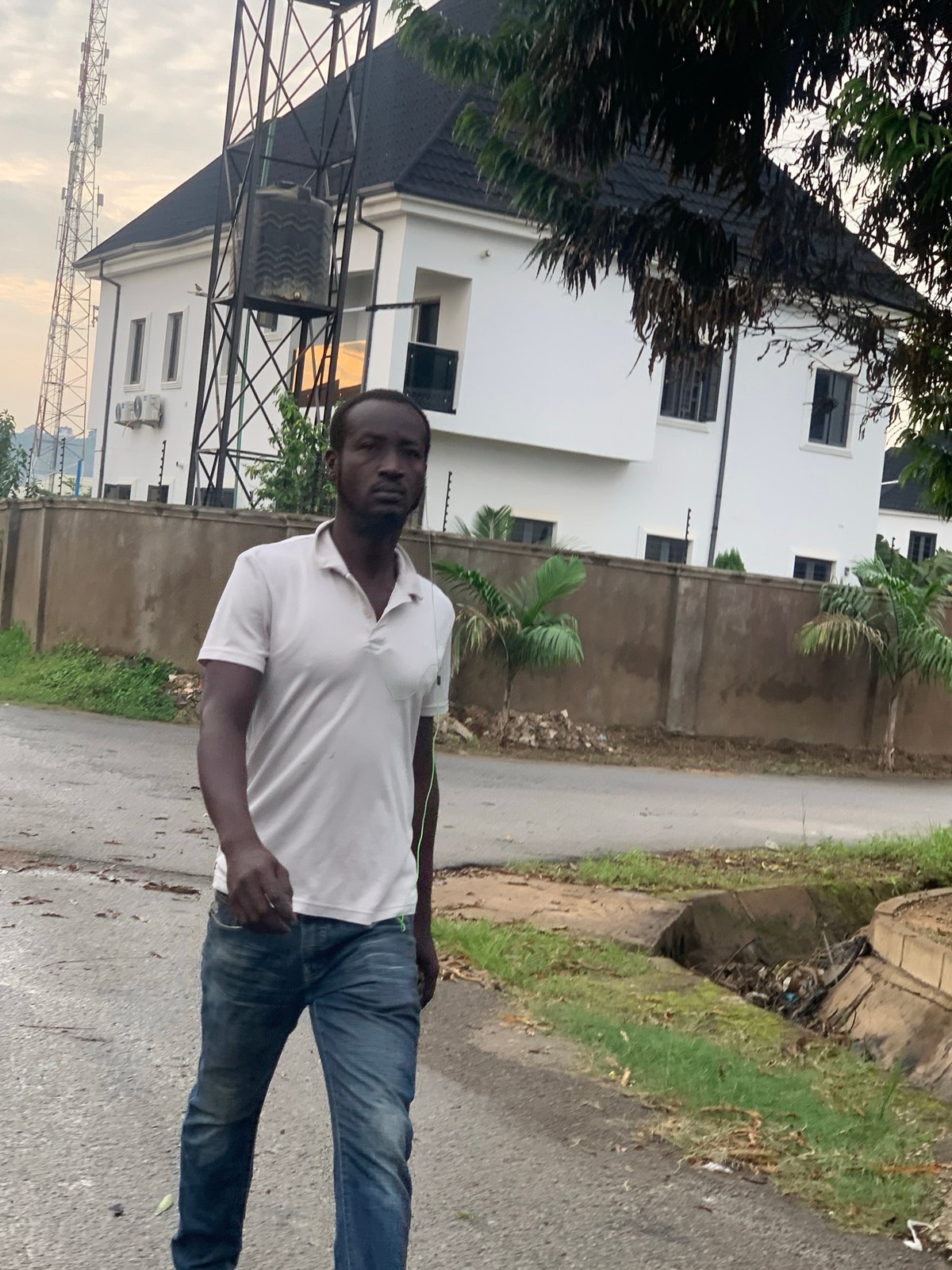 Wet morning street life in a residential Abuja neighborhood