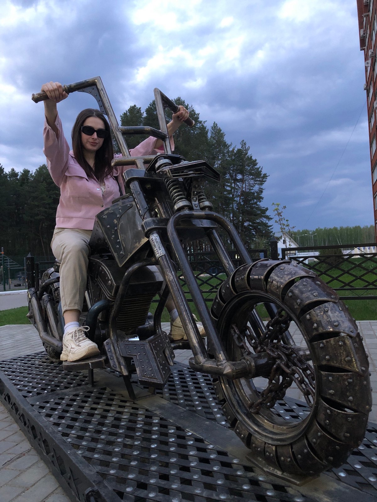 Woman poses on motorcycle sculpture in Chaikovsky, Russia