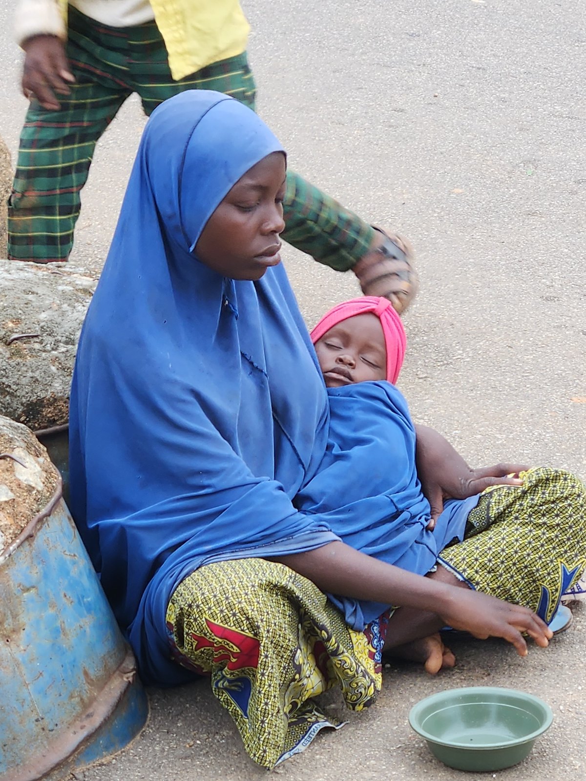 Street scenes captured showing women, infant, metal rod carriers