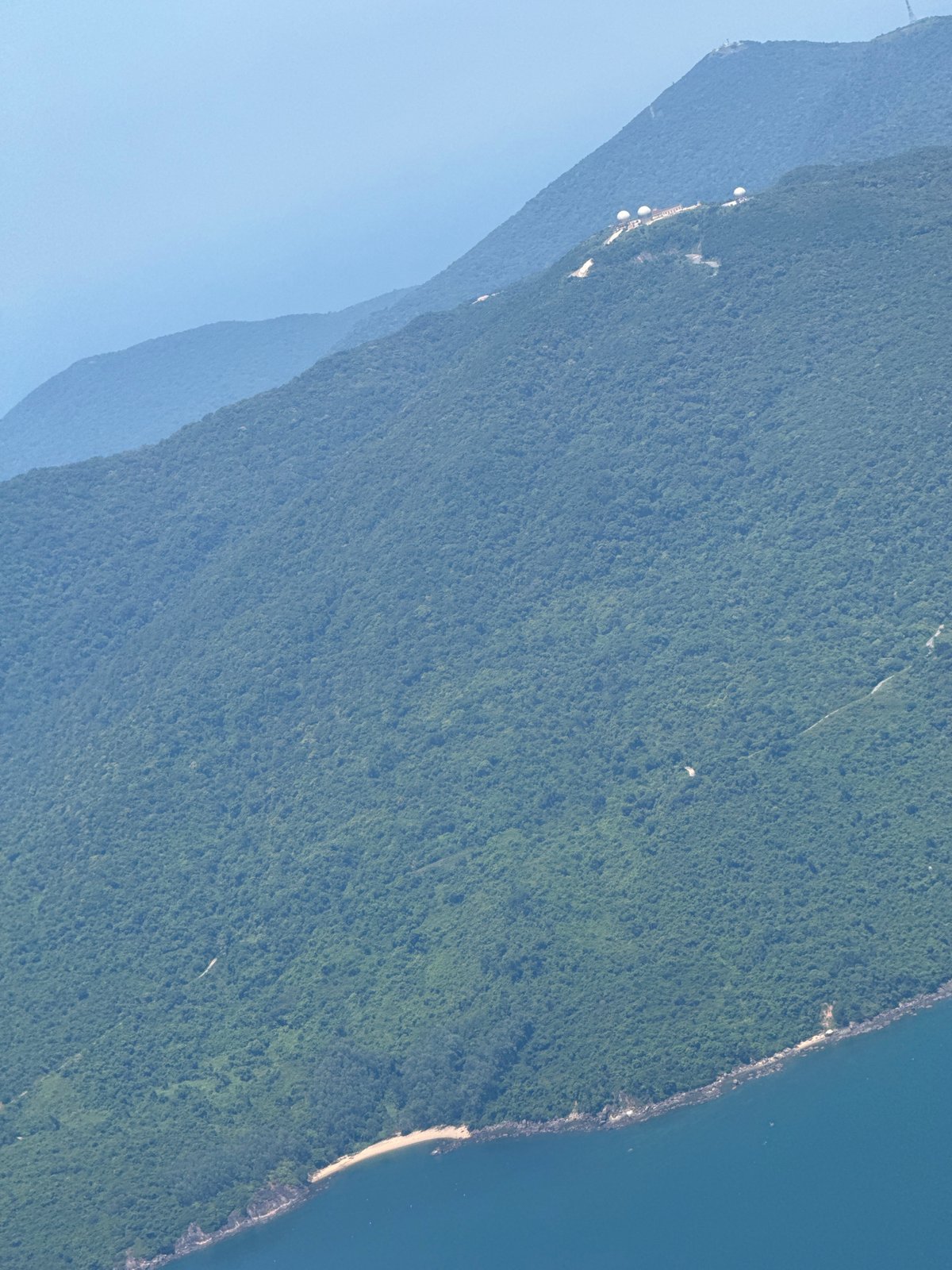 Aerial view shows dense forest meeting coastline near Đà Nẵng