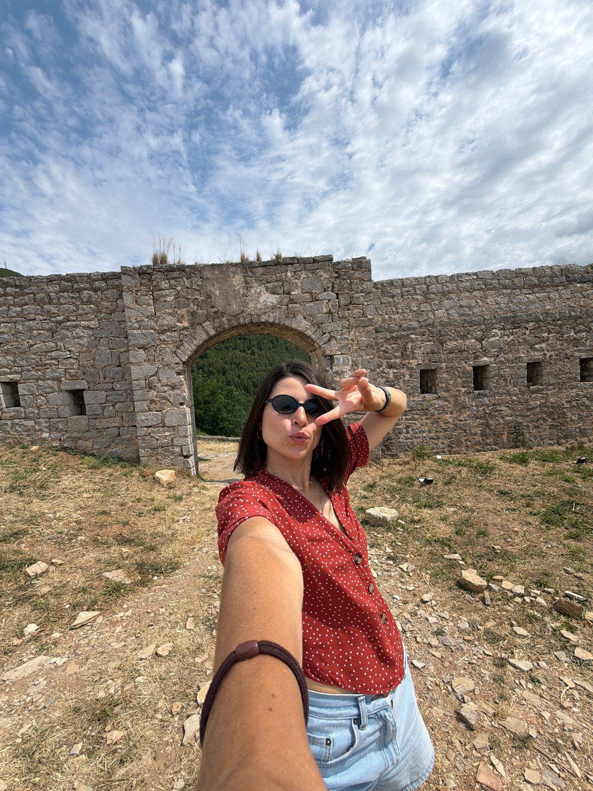 Tourist captures clifftop selfies at historic Budva ruins overlooking Adriatic