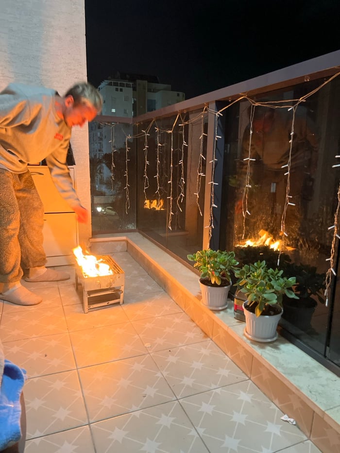 Family enjoys evening barbecue on balcony in Kiryat Bialik
