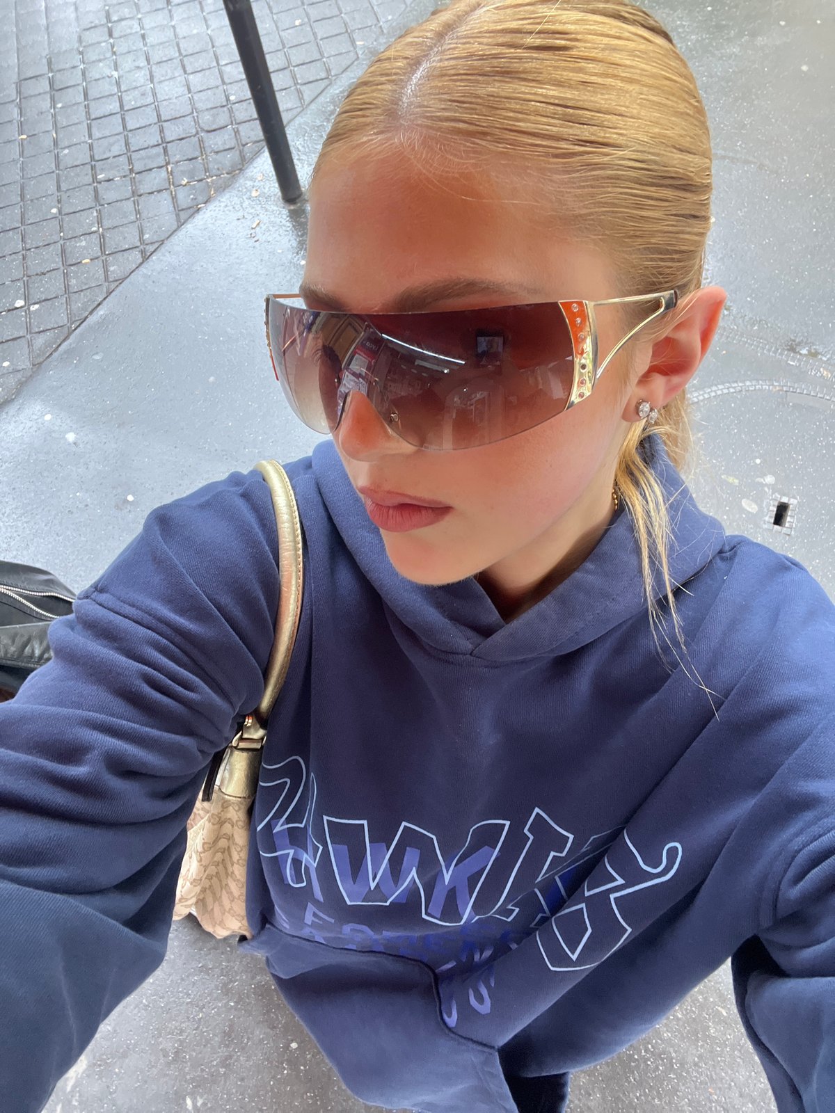 Woman in blue hoodie observed on wet Paris street